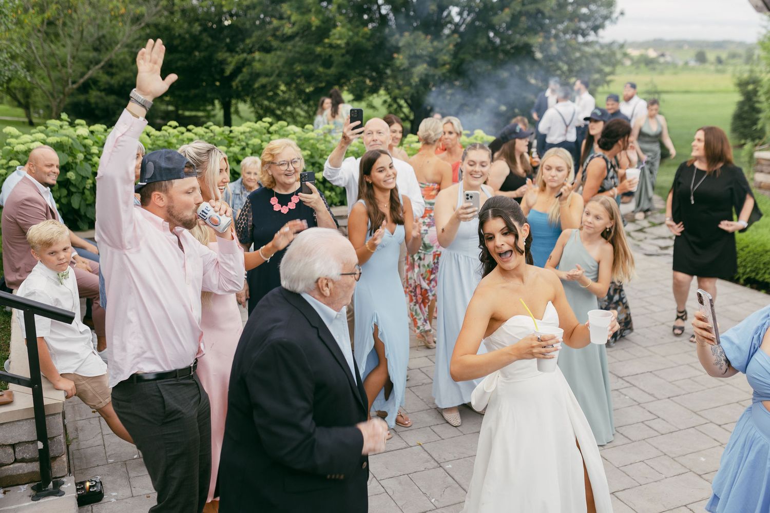 Wedding celebration on outdoor patio with guests dancing and celebrating.