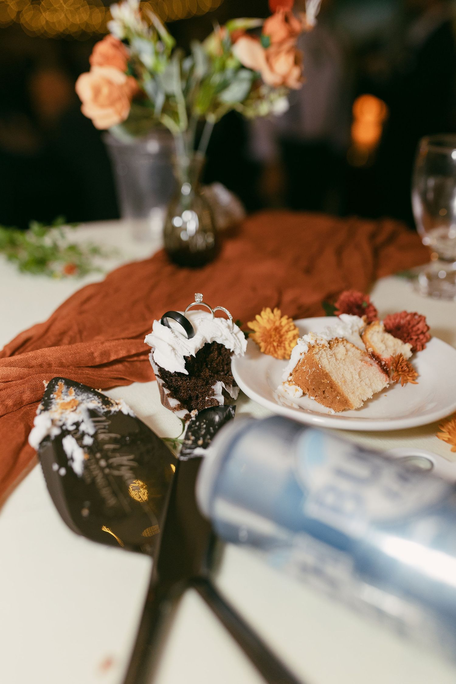 Wedding reception table settings with rust-colored linens and elegant place settings.