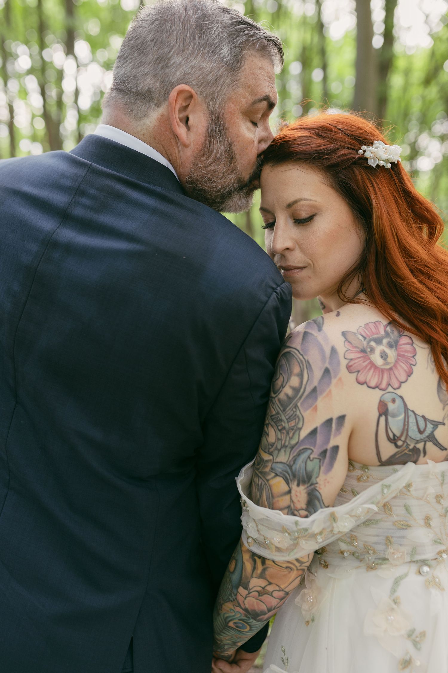 Intimate wedding portrait showing detailed lace dress and colorful tattoo art.