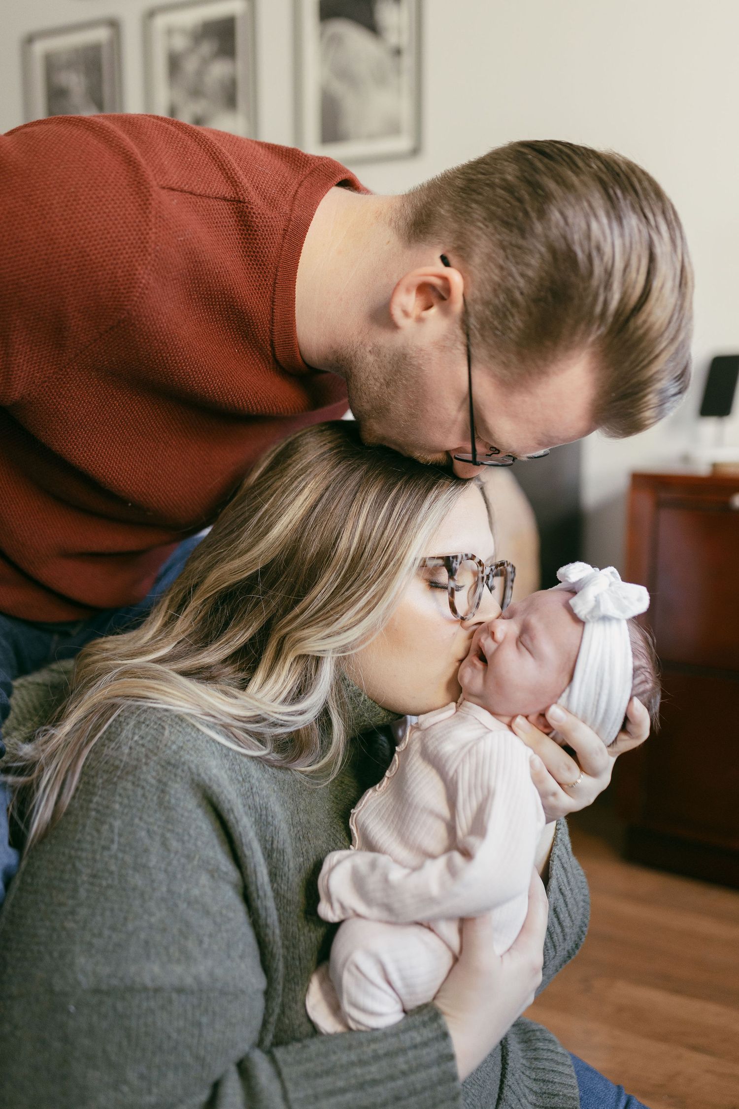 Indoor lifestyle photos of parents sharing tender moments with their newborn.