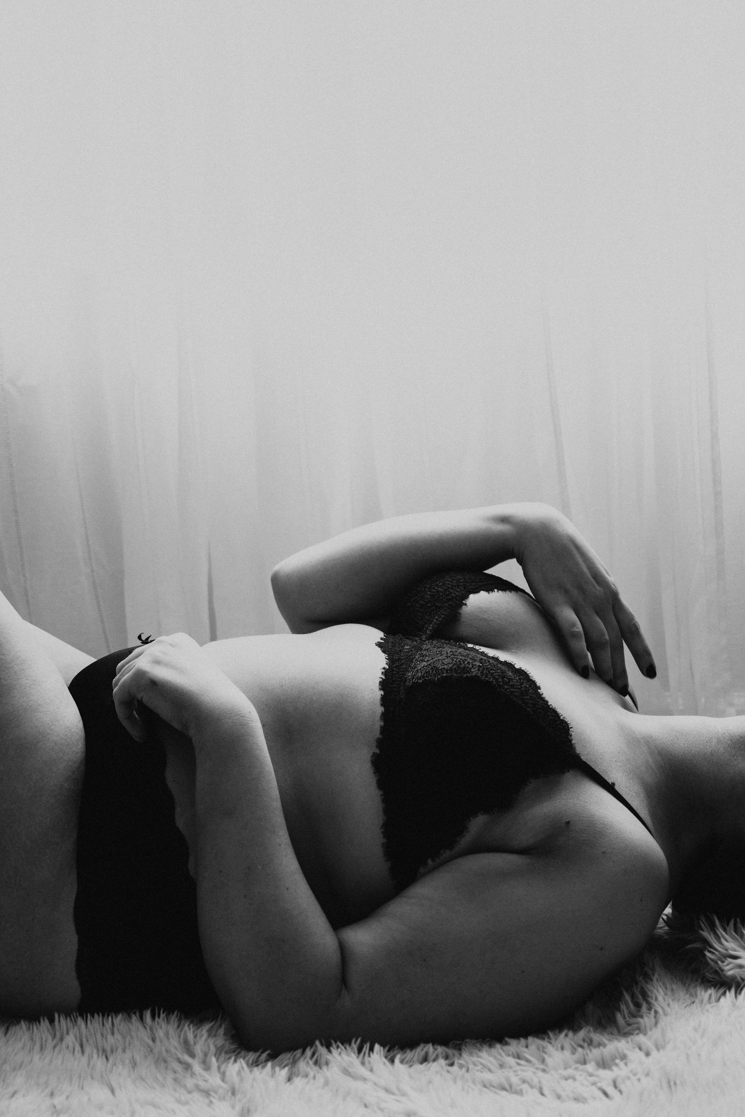 Artistic black and white boudoir photo showing silhouette against soft lighting.
