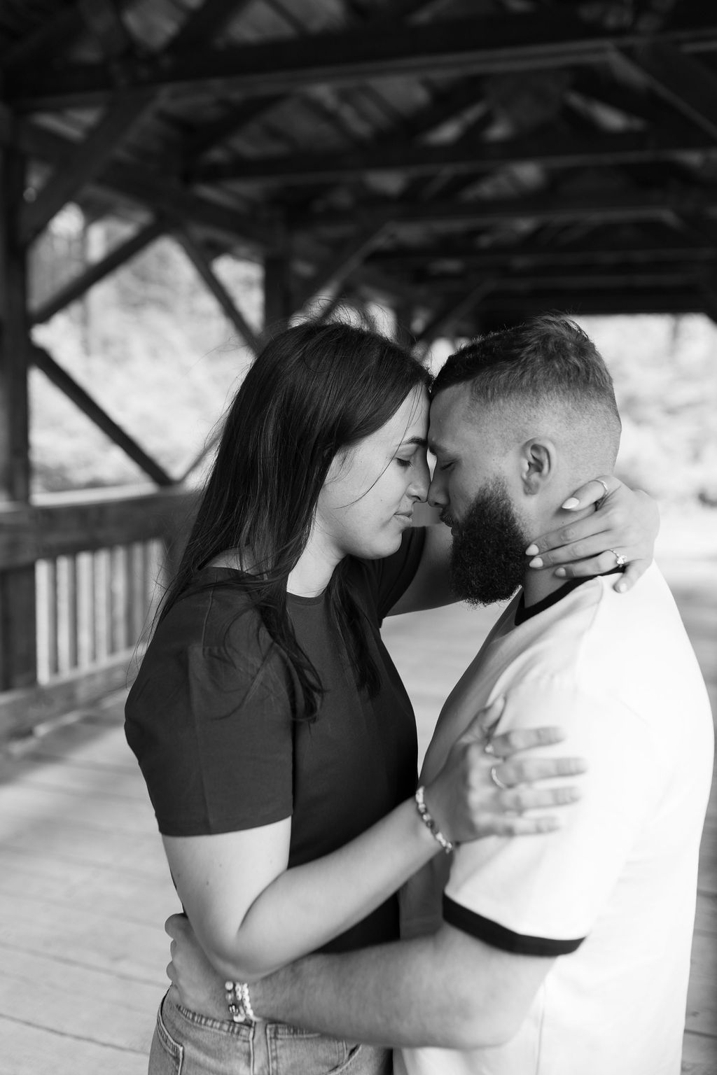 Black and white photos of couple sharing romantic moments under covered structure.