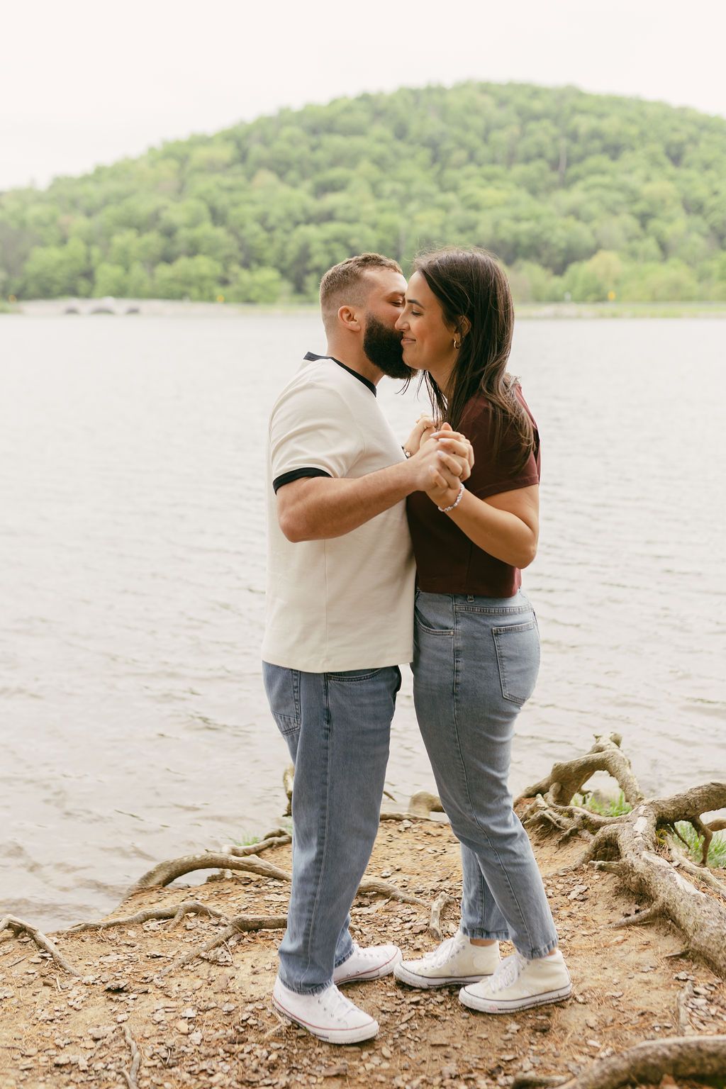 Couple sharing tender moments by a serene lakeside.