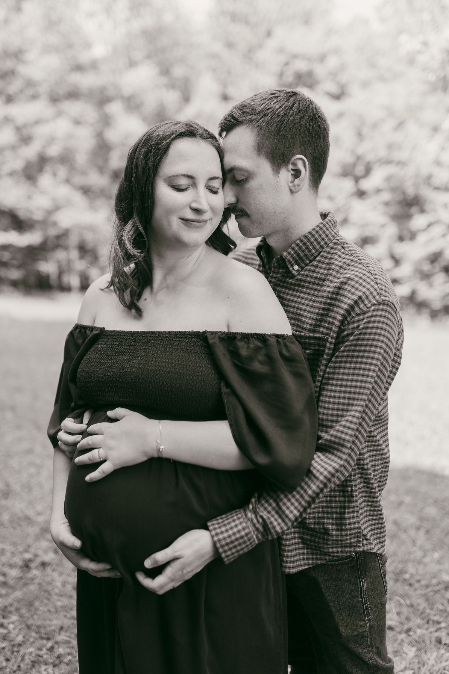 Black and white maternity photo session showing intimate couple moment.