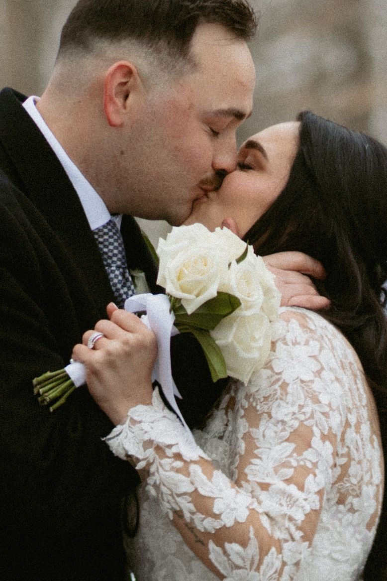Romantic wedding portraits featuring white roses and delicate lace dress details.