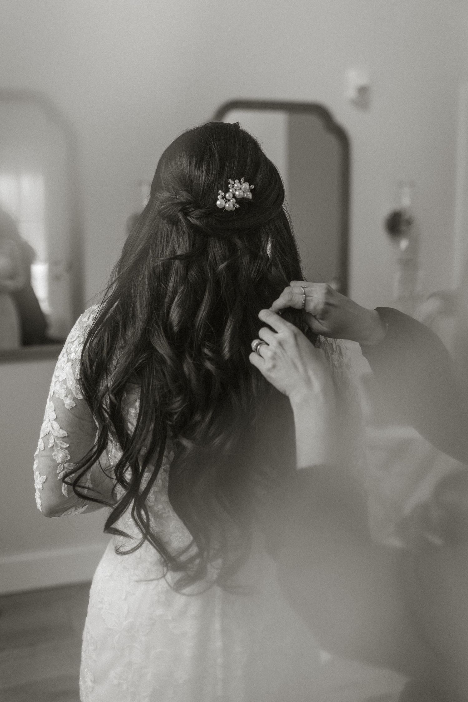 Black and white photos capturing wedding day preparation moments with flowing veil and lace details.