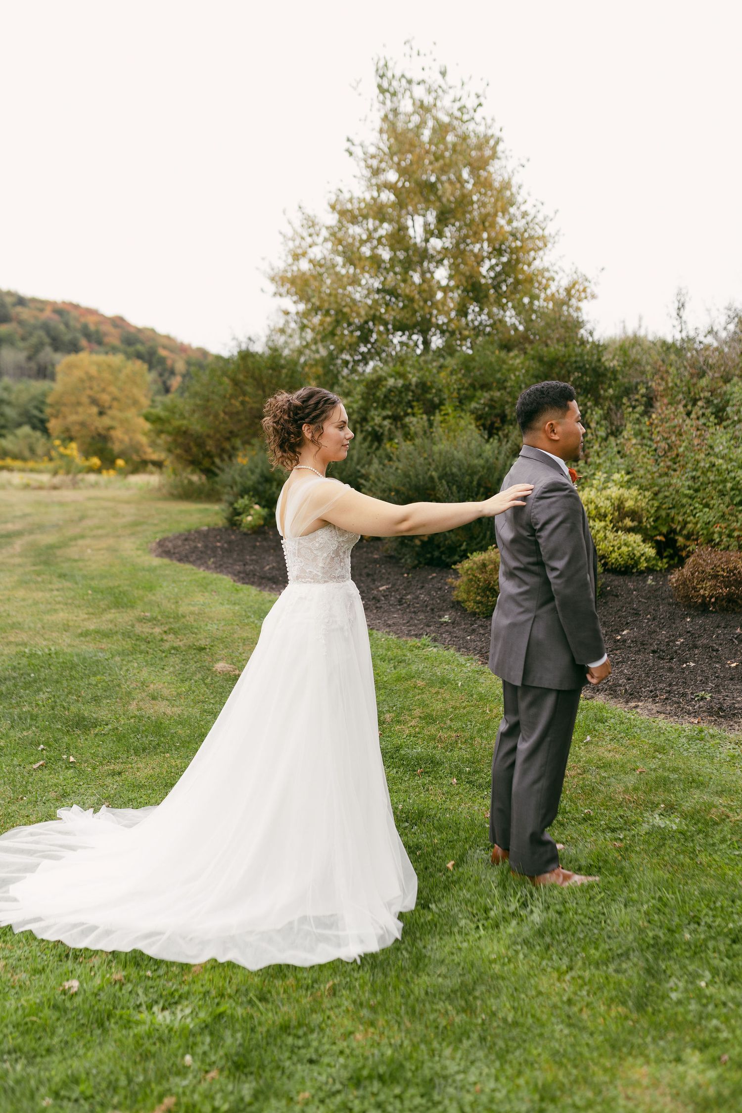 Wedding couple doing their first look moment in a garden setting during autumn.