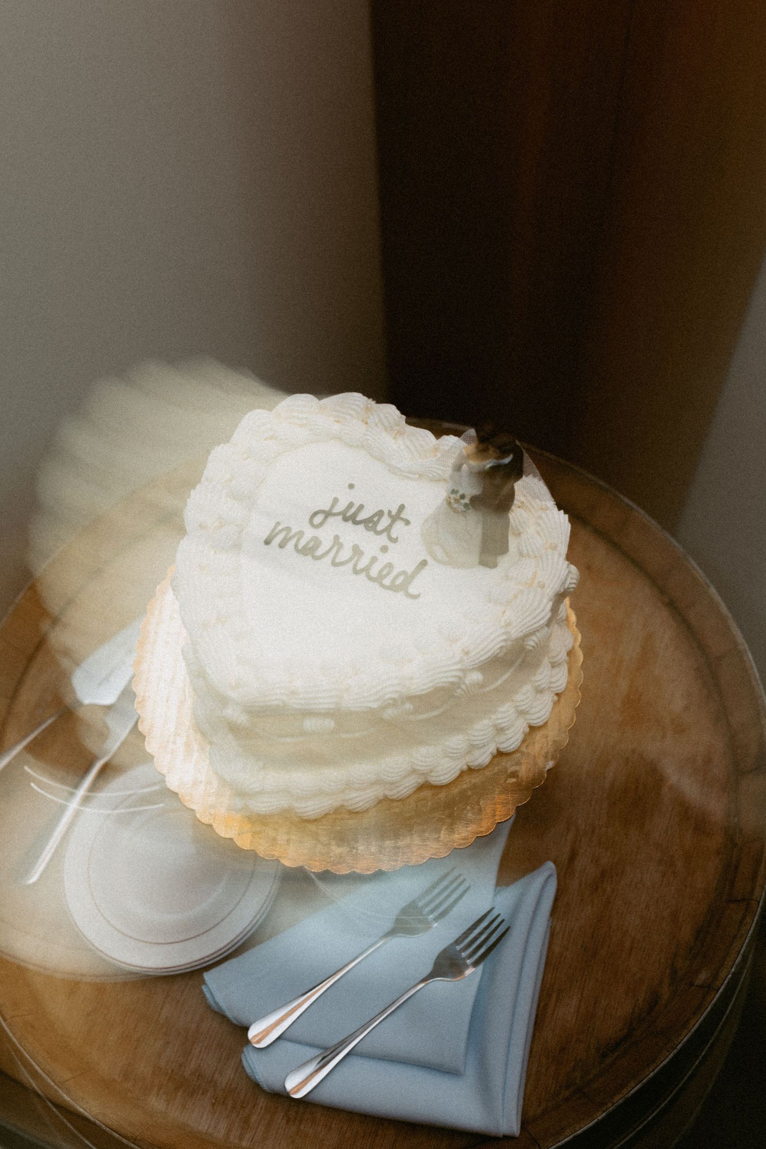 Close-up of an elegant white wedding pie with delicate frosting on a wooden surface.