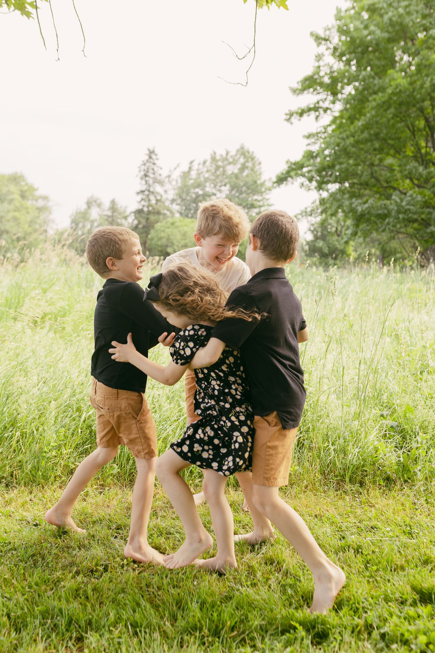Children playing and running together in a grassy field on a sunny summer day.
