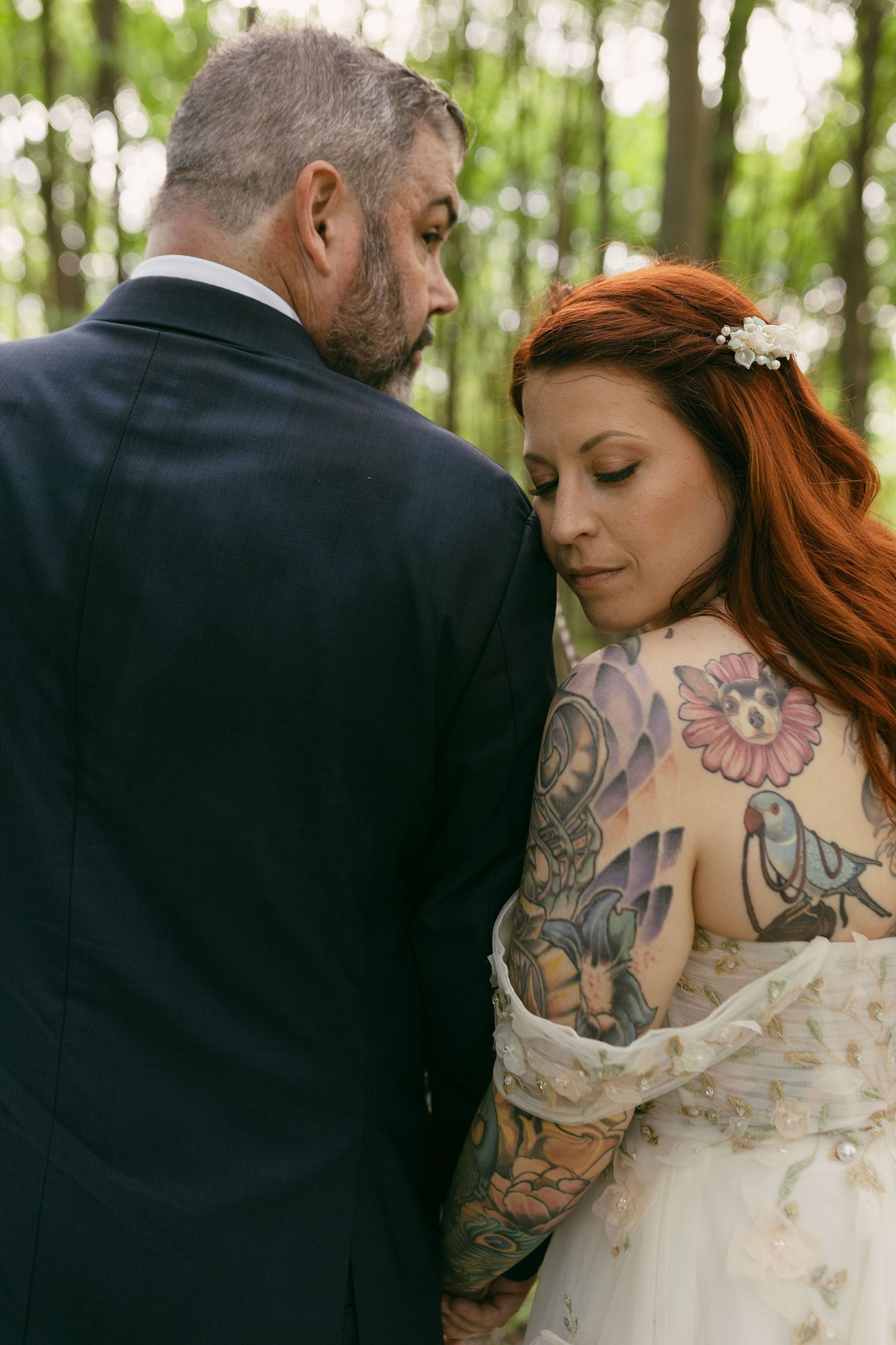 Close-up wedding photography highlighting intricate dress details and artistic tattoos.