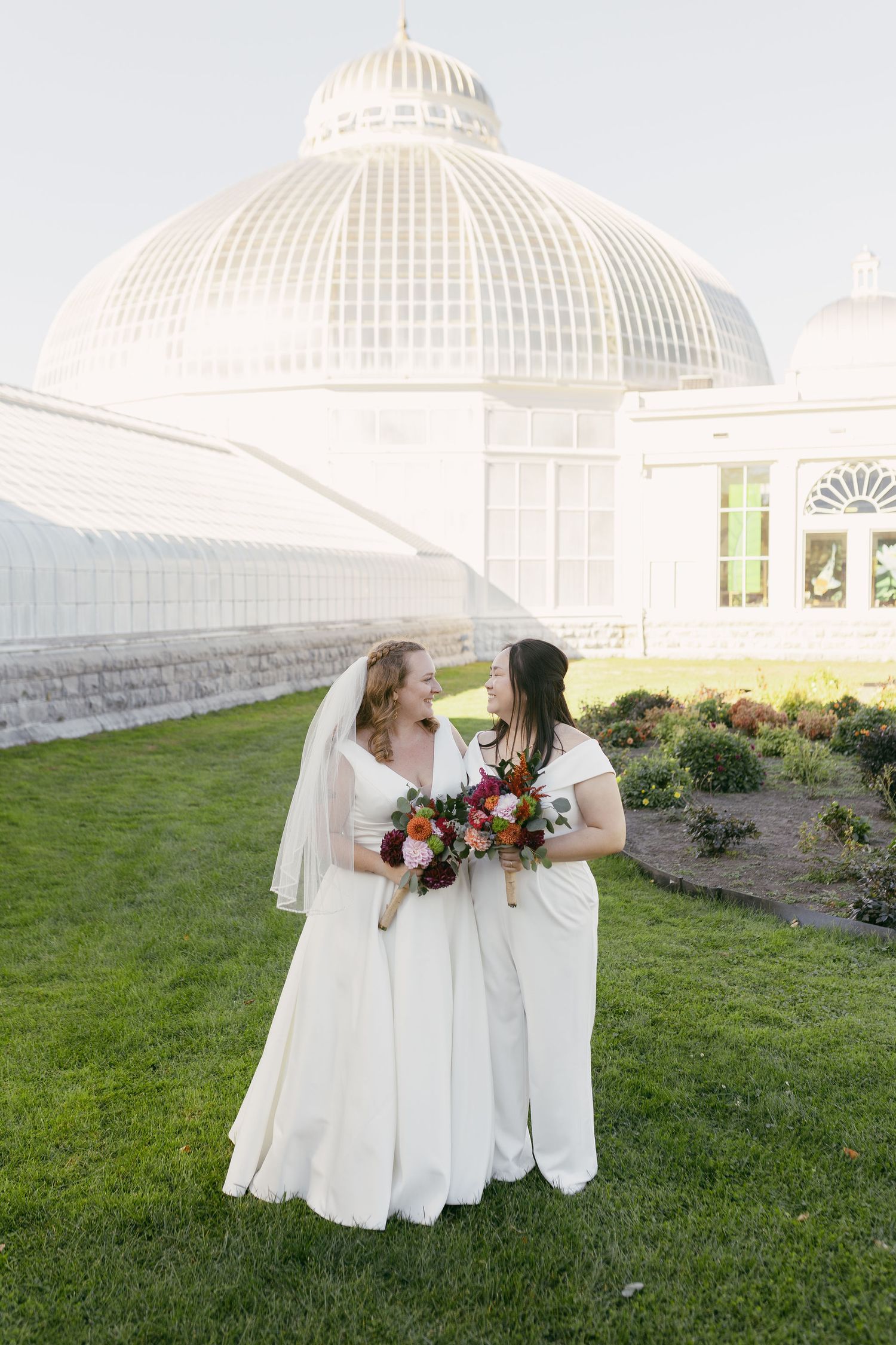 Wedding portraits taken outside a grand conservatory with white domed architecture.