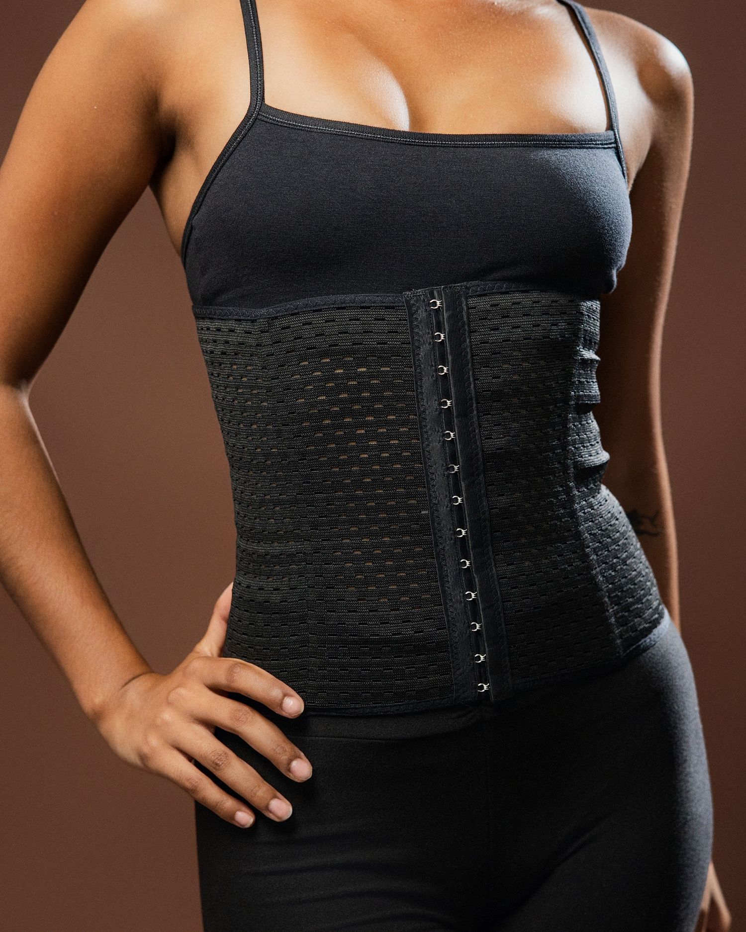 Close-up shots of black waist trainer with hook closures and textured pattern.