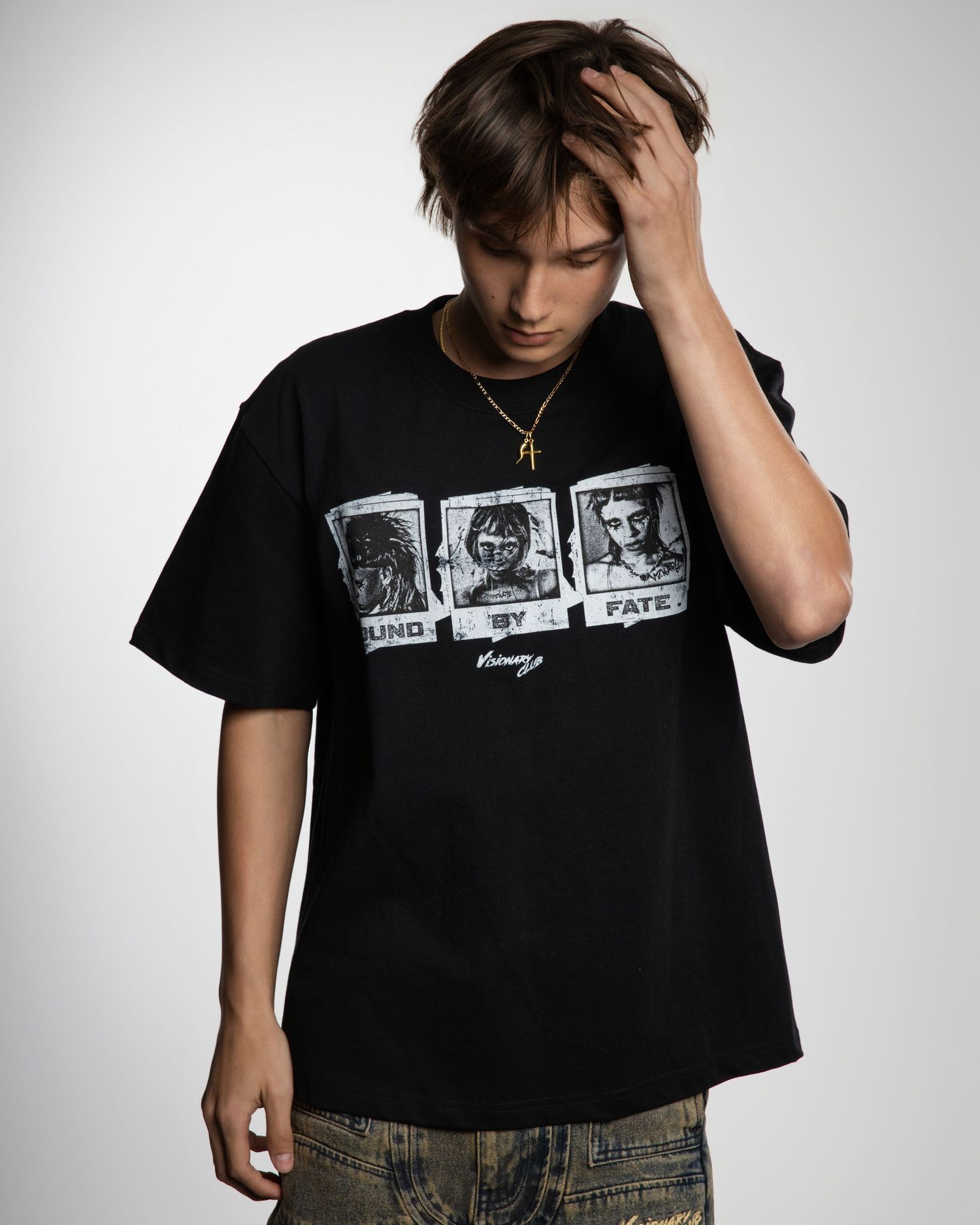 Someone wearing a black graphic t-shirt with three photo frames printed on it poses against a light gray background.