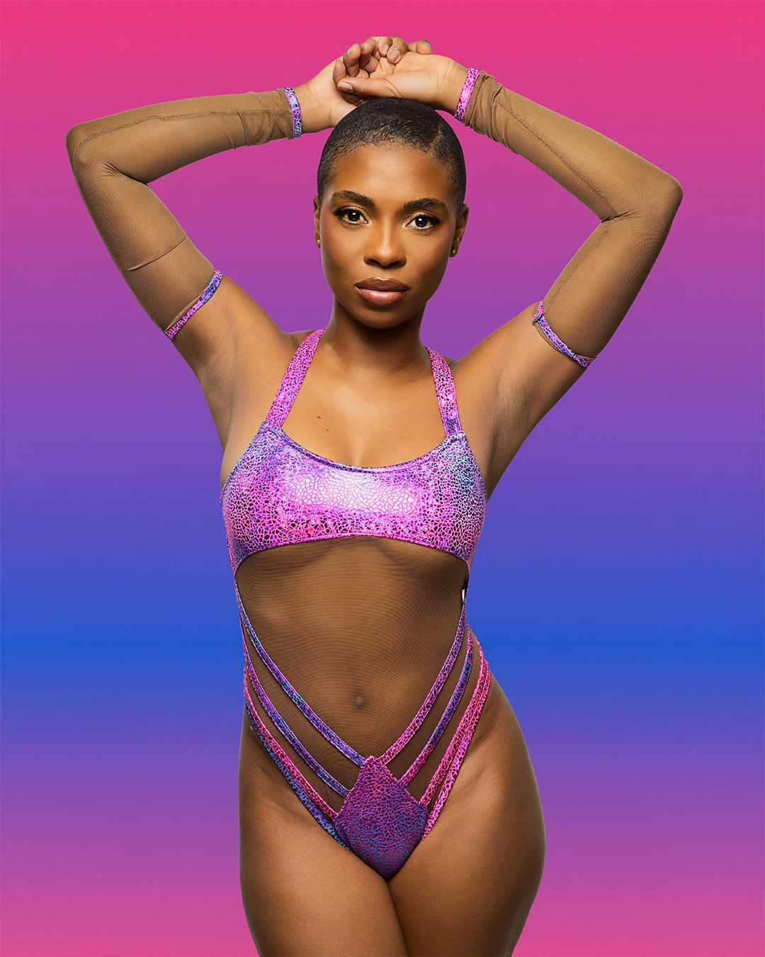 Athletic figure shown in vibrant pink and purple gradient lighting wearing sparkly pink and purple dance attire.