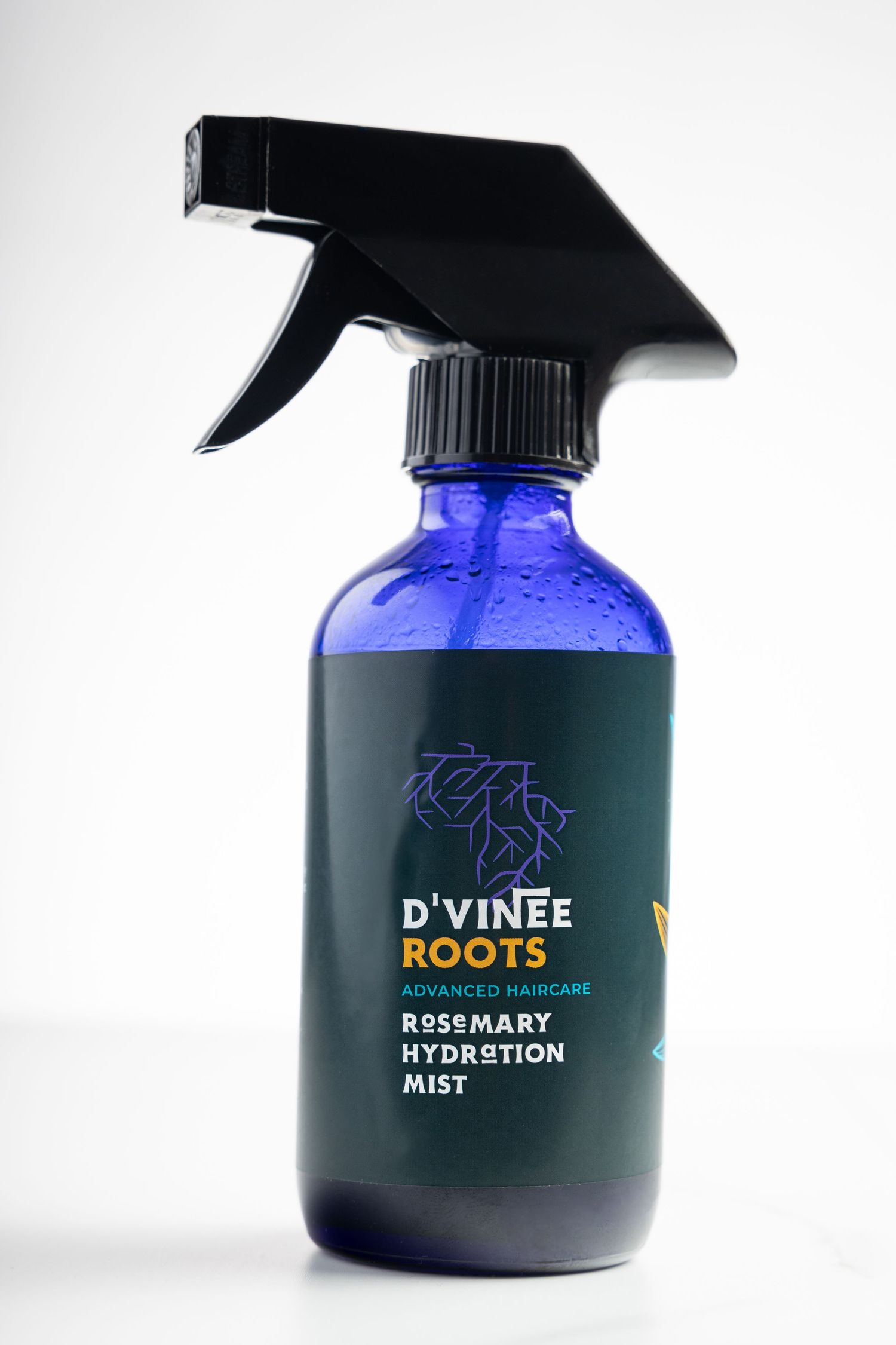 Three blue glass spray bottles with black nozzles featuring minimalist branding and product labels against a white background.