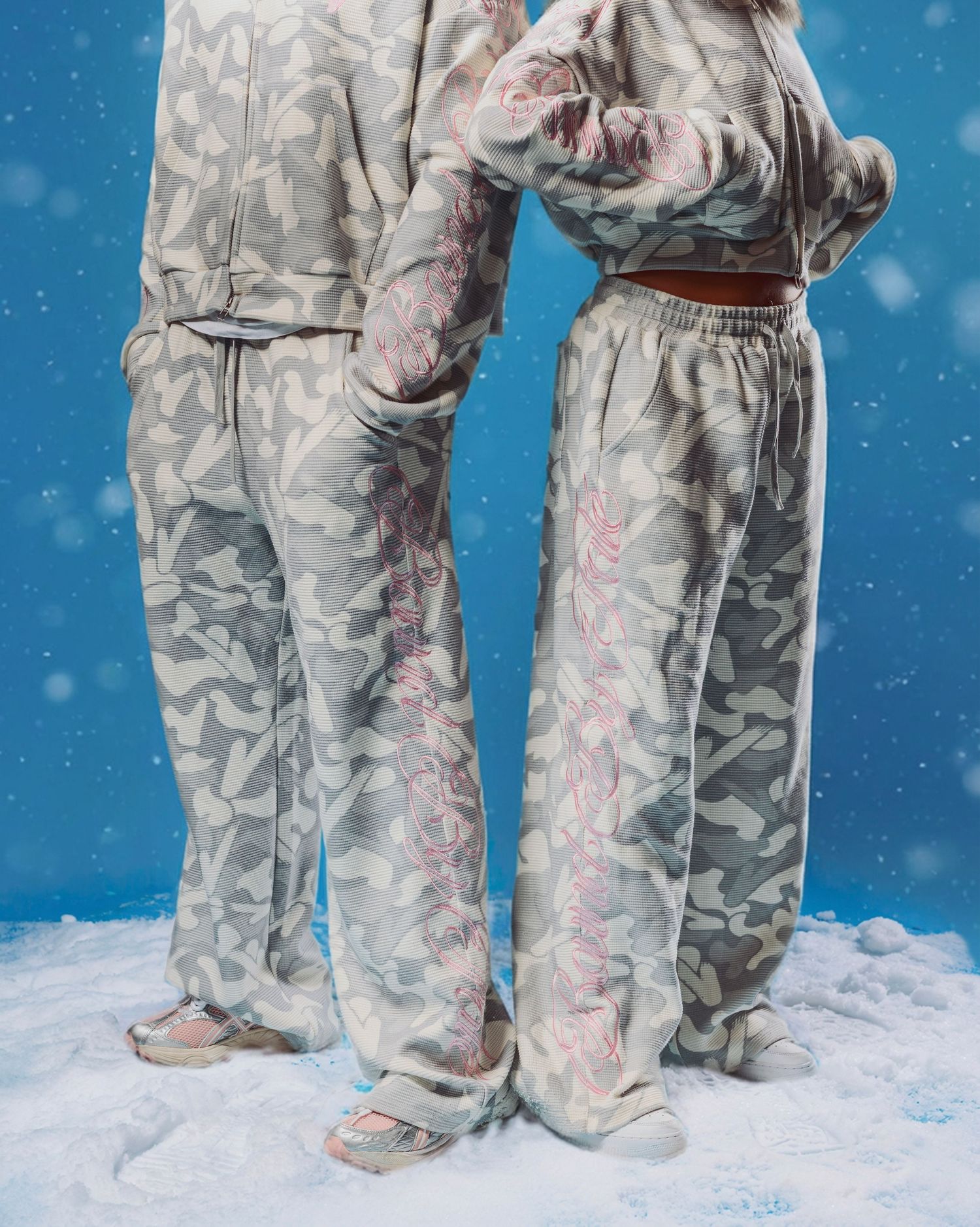 Close-up views of legs wearing camouflage pants and boots standing in snow against a blue background.