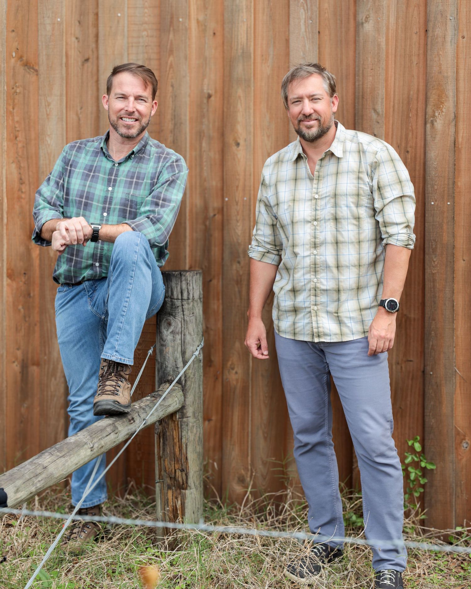 A person wearing plaid shirt and jeans demonstrates four progressive steps of chopping wood with an axe against a fence.