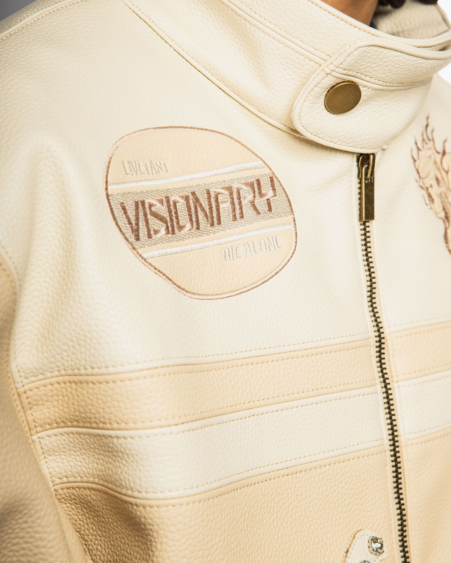 Close-up view of white leather handbags with gold zipper details and brand logos arranged in a row.