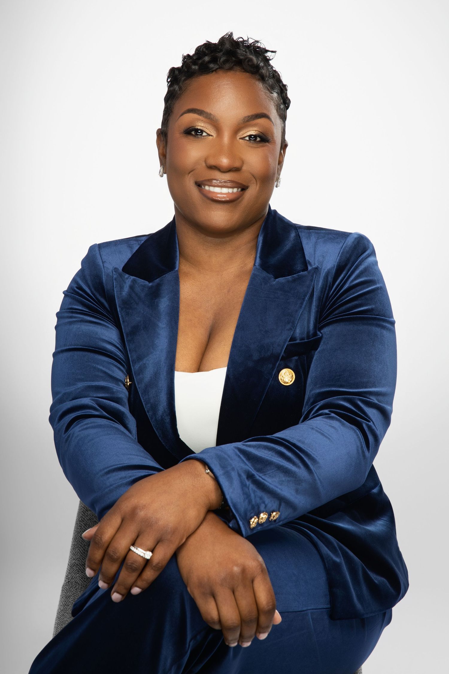Professional portraits in navy velvet blazer against white studio background.
