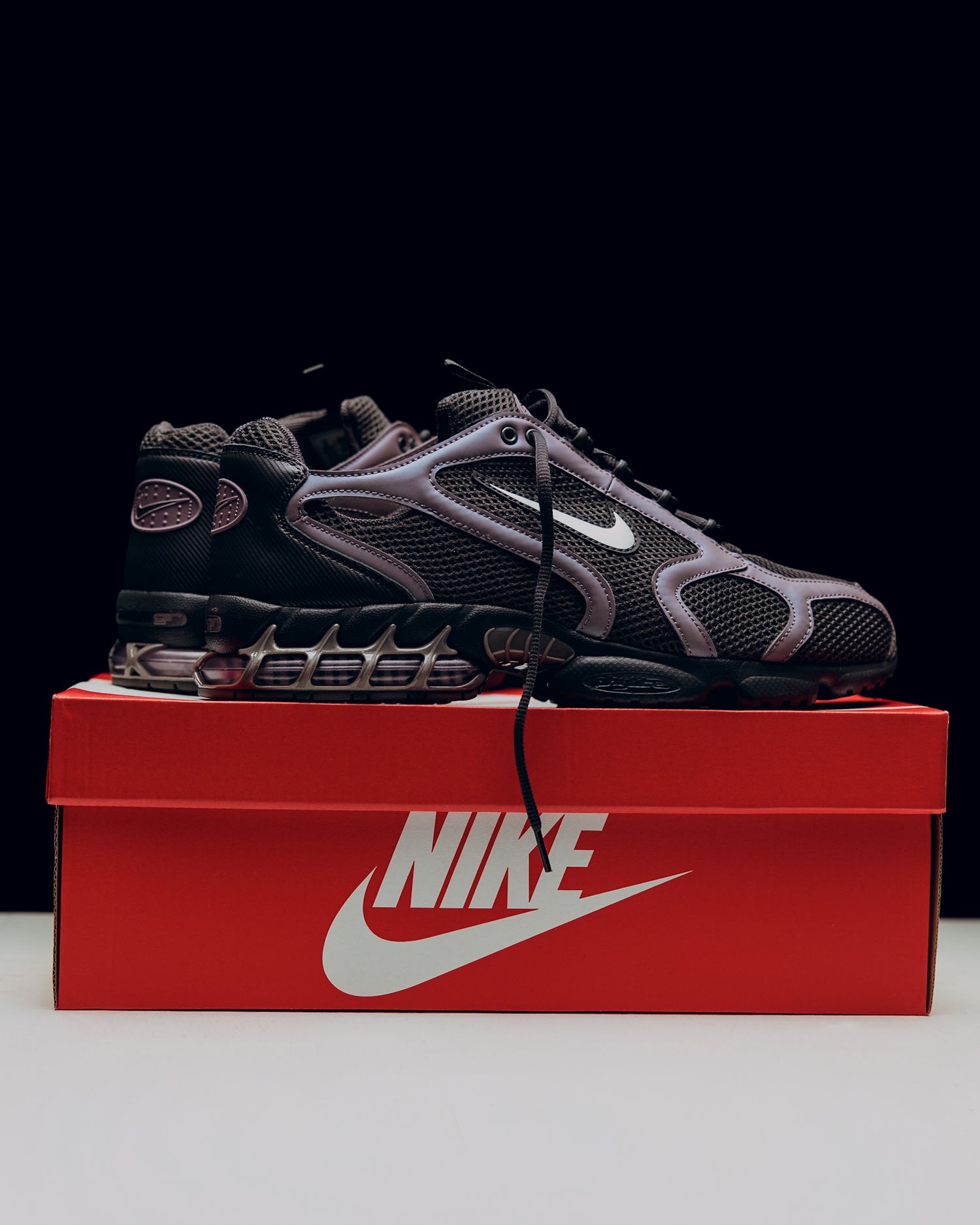 Multiple angles of a black and gray Nike sports sandal displayed on a red Nike shoe box.
