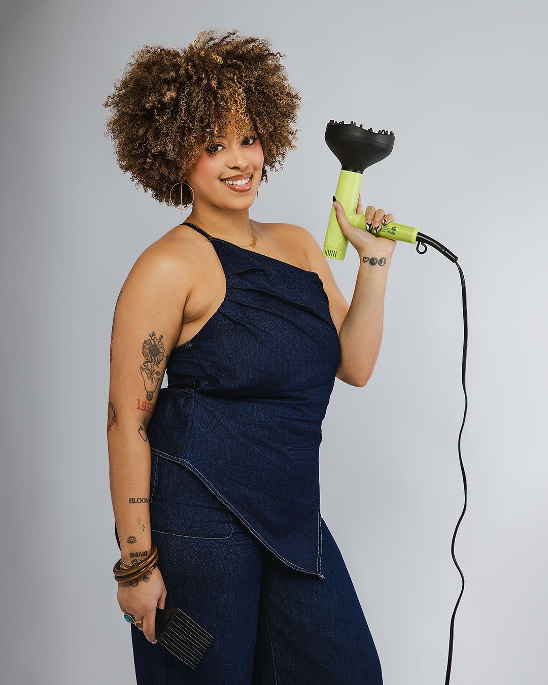 Person in navy blue one-shoulder dress holding microphone against white backdrop in dynamic poses.