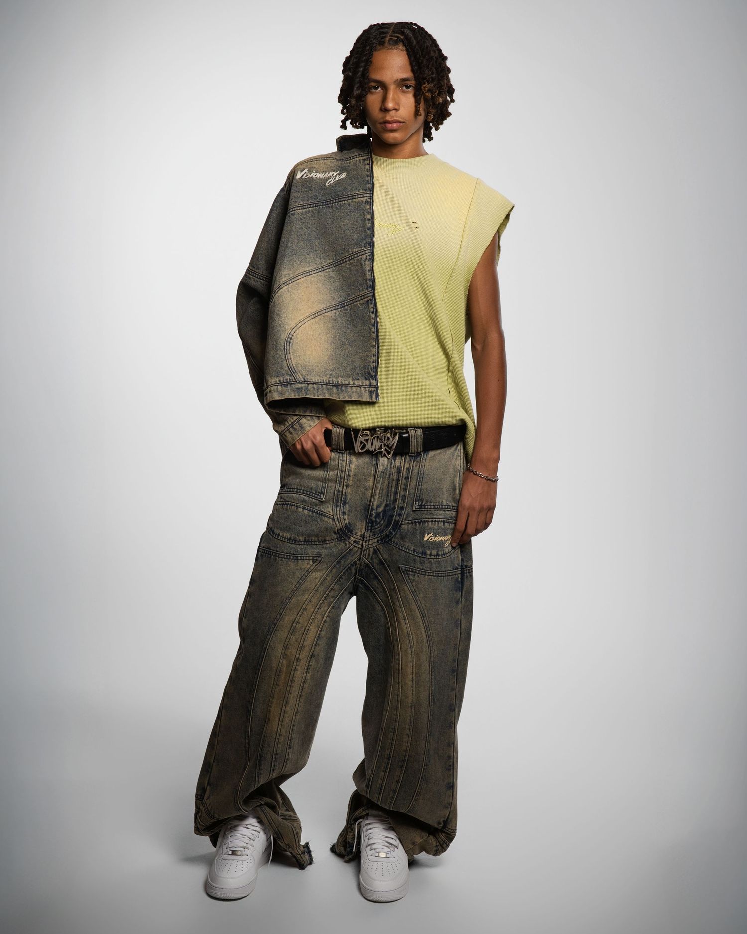 Person wearing yellow sleeveless top and oversized denim jeans poses in different angles against white background.