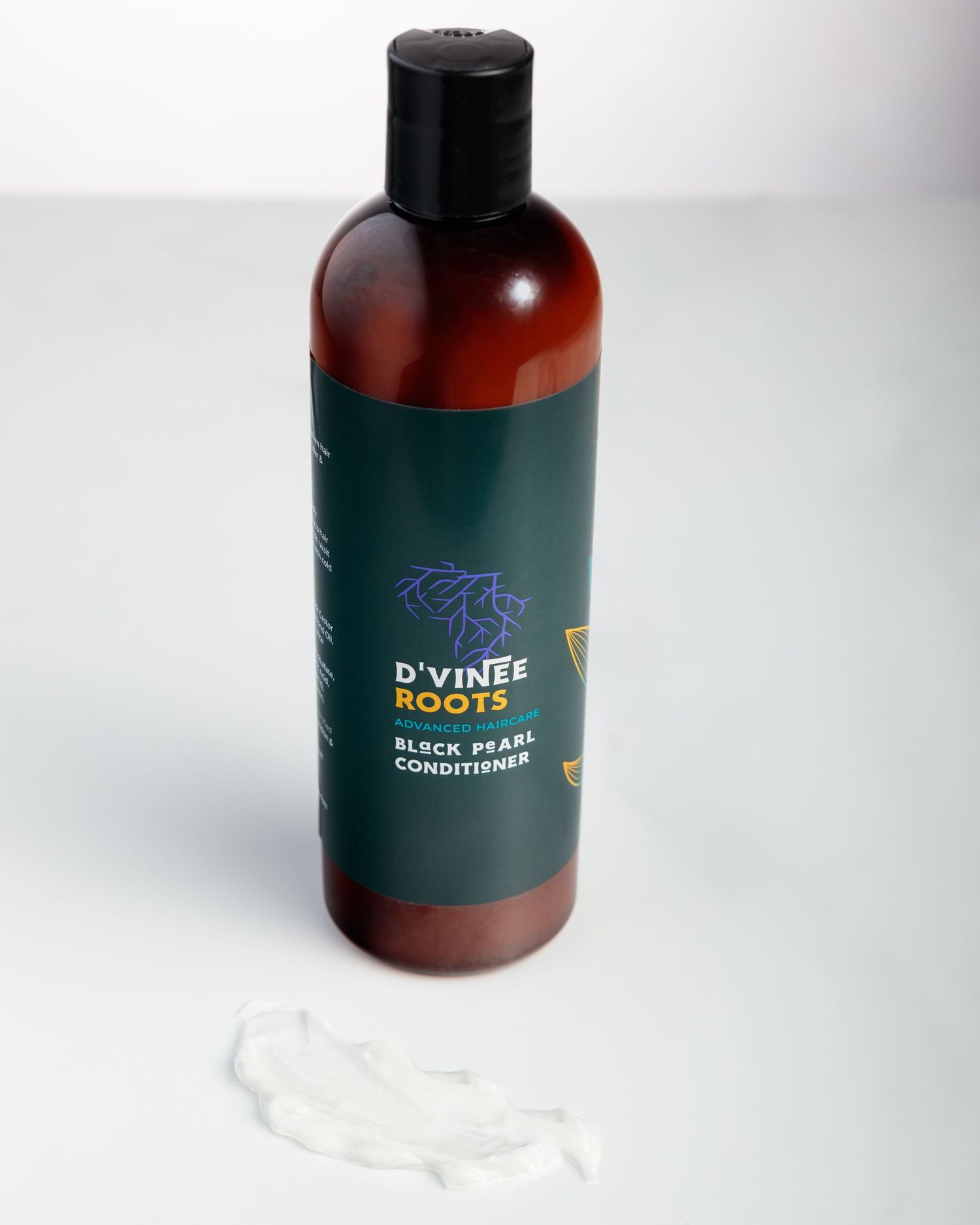 A bottle of D'vine Roots black pearl conditioner in amber glass with dark green label against a light background.