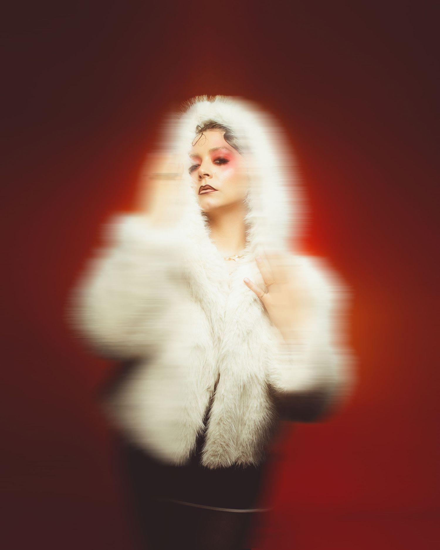 Editorial-style studio portrait featuring red backdrop and soft lighting.