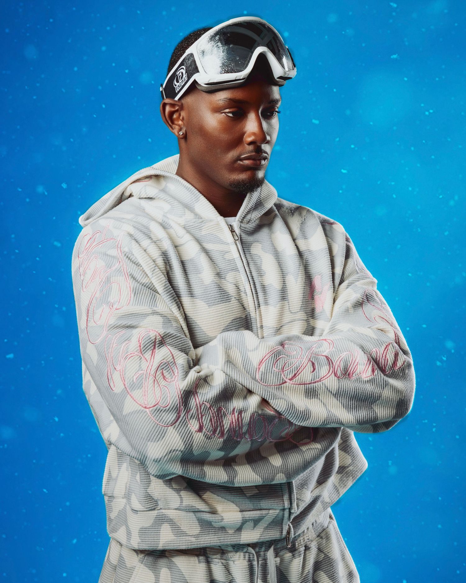 Person wearing protective white hazmat suit and goggles poses against blue background in multiple angles.