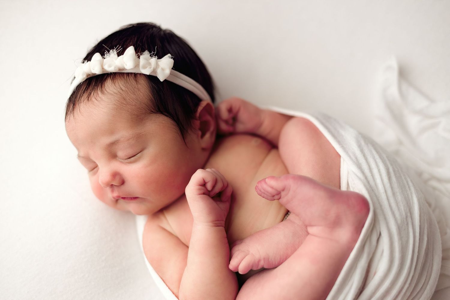 A collage of four peaceful sleeping newborn baby photos on a white background.
