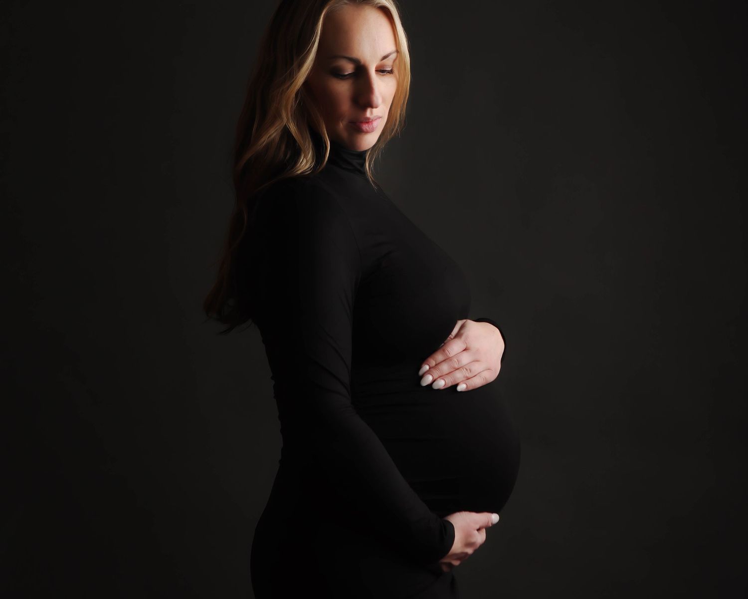 A figure in a black turtleneck poses gracefully against a dark background in a series of dramatic studio portraits.