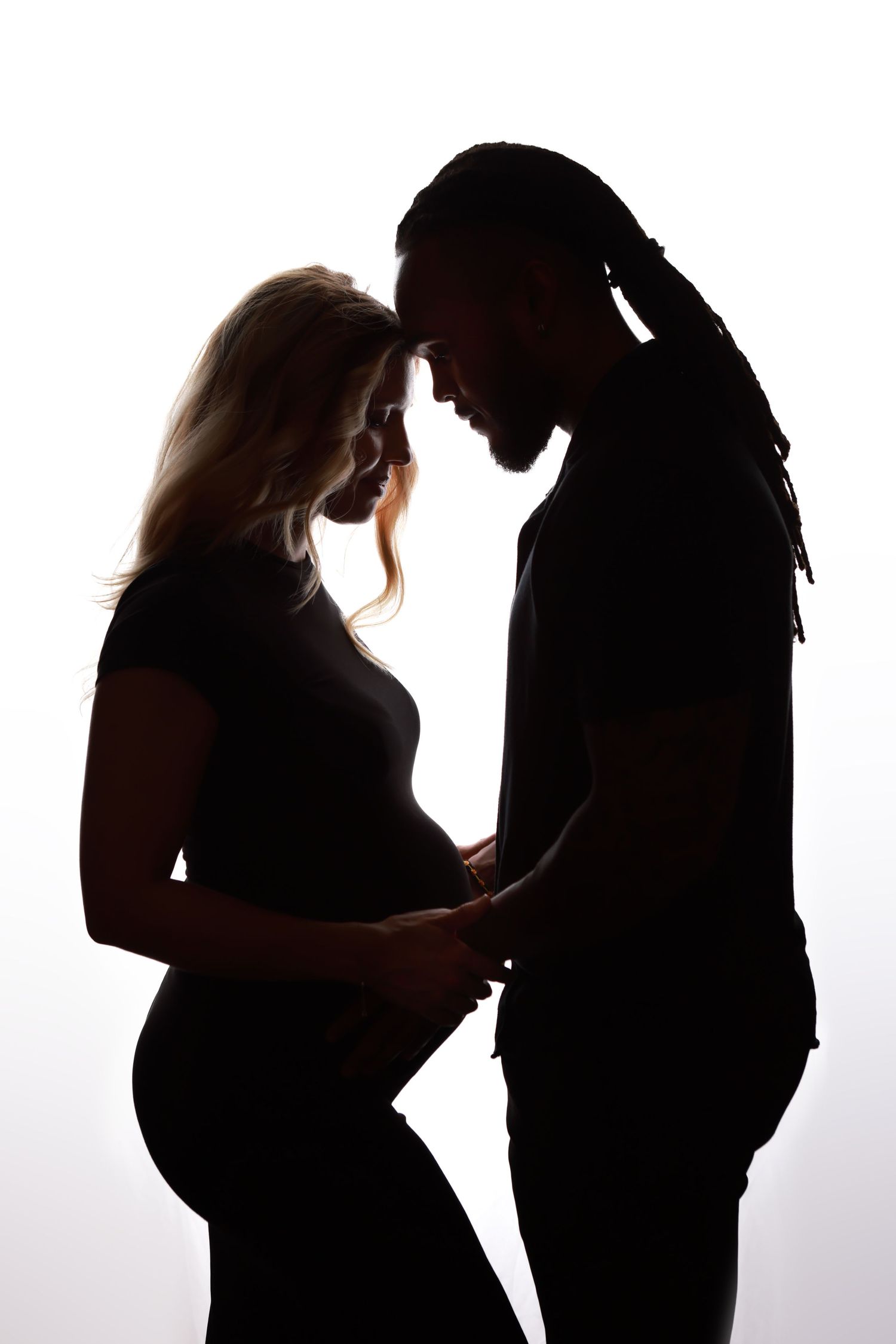 Silhouette maternity progression photos showing growing baby bump against white background.