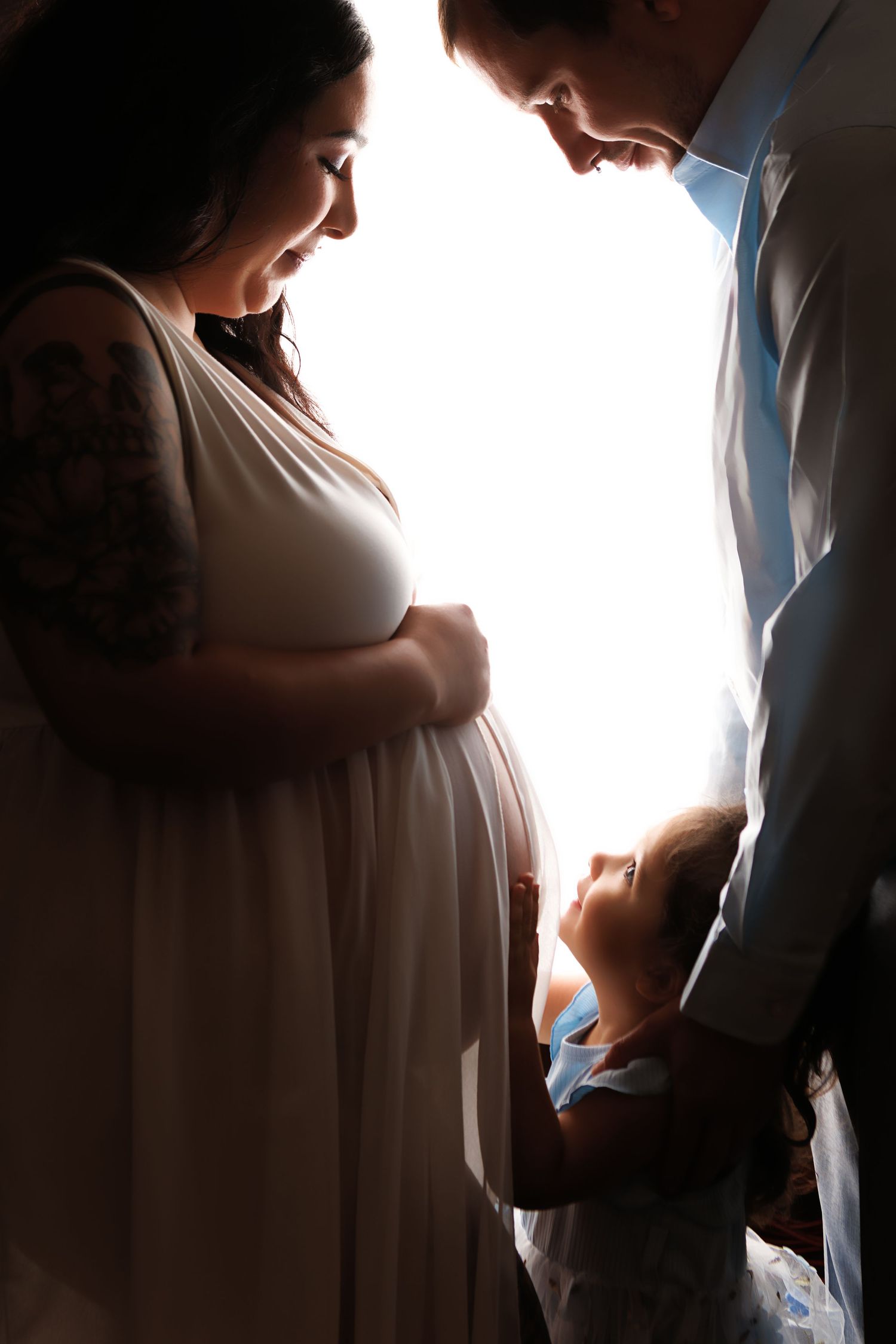 A silhouetted figure stands by a bright window in a series of intimate, backlit photographs.