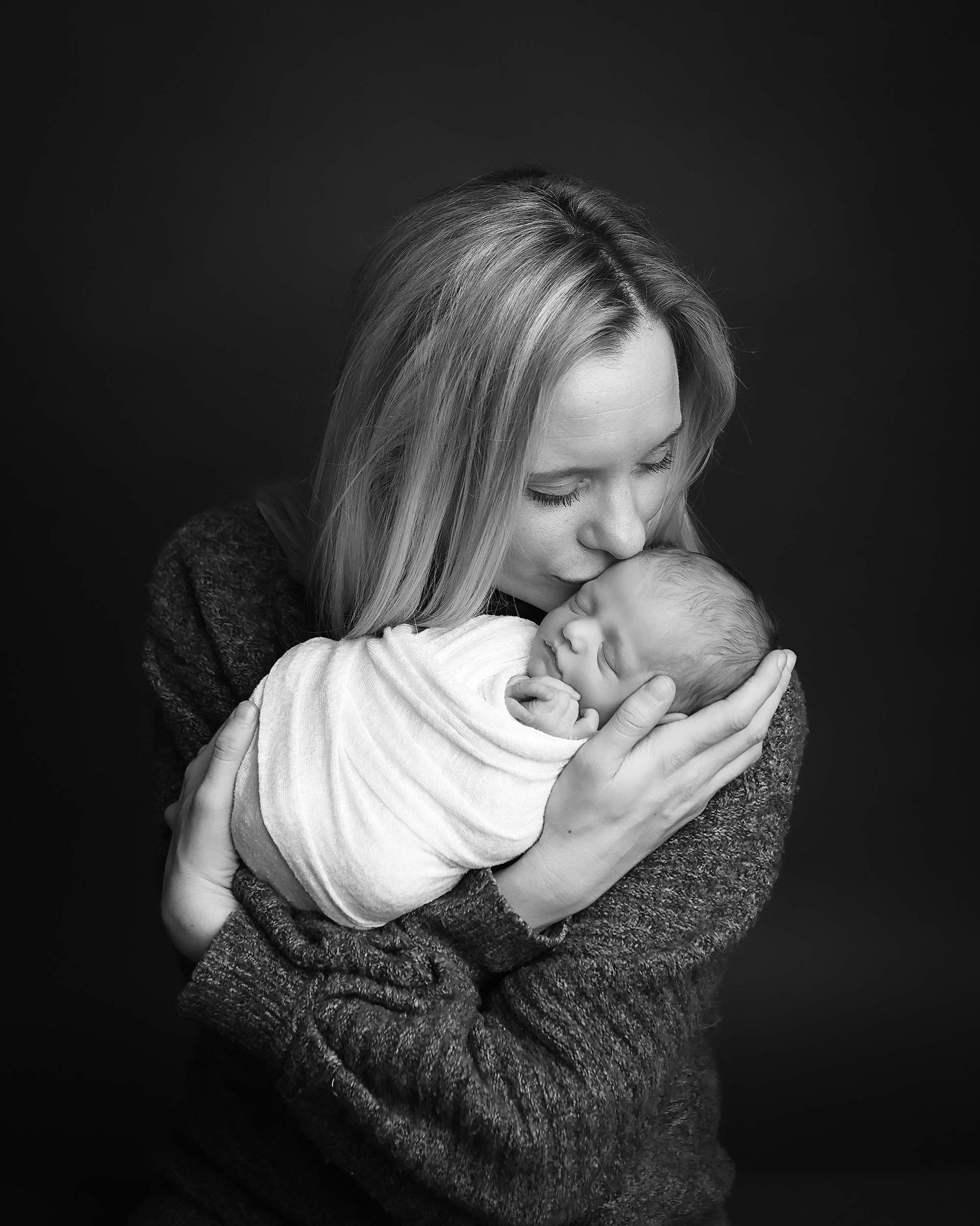 Intimate black and white portrait series showing tender maternal embrace.