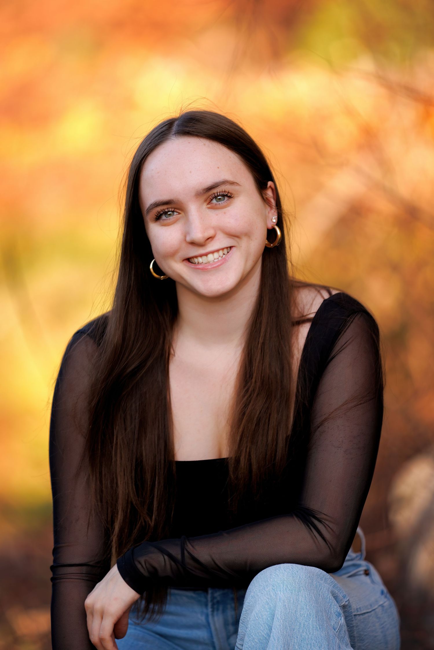 Portrait photo series with autumn foliage creating a warm golden bokeh background. High School Senior.