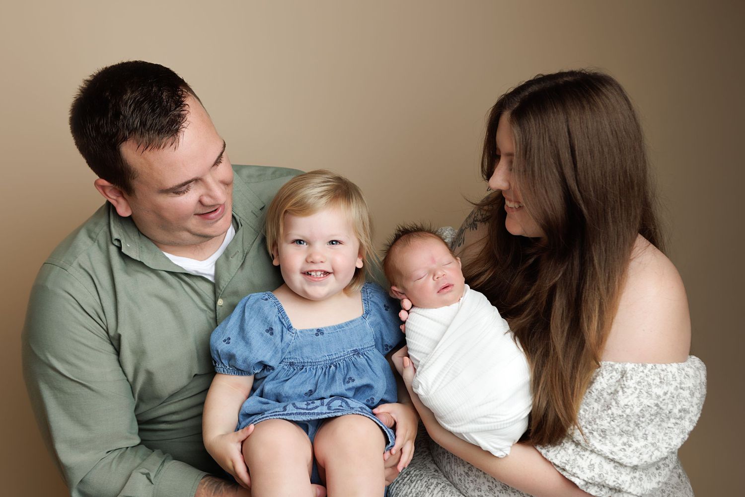 A series of tender family portraits showing parents with young children in soft, natural lighting against neutral backgrounds.