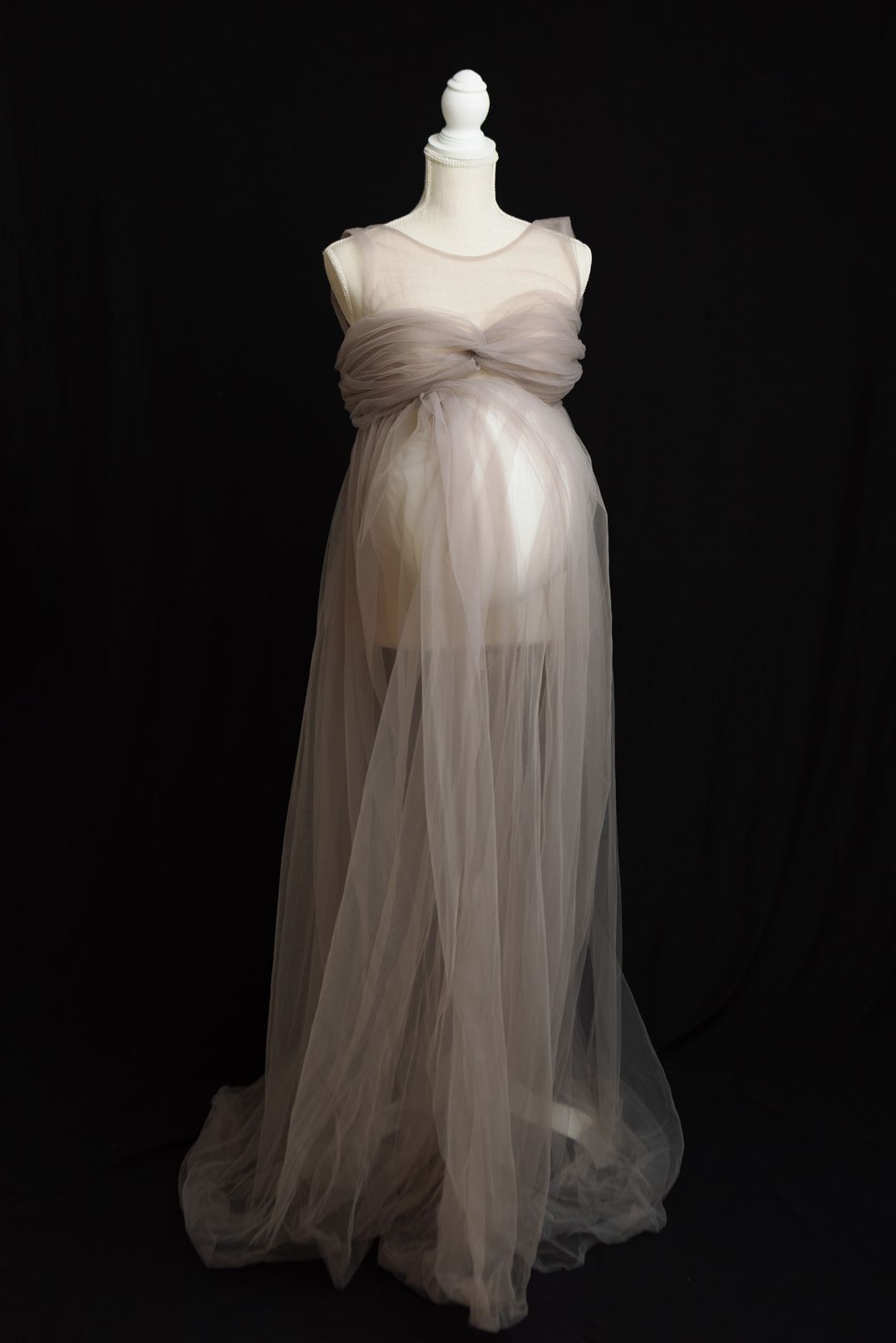 A flowing white chiffon maternity dress with sweetheart neckline displayed on a mannequin against a black background.