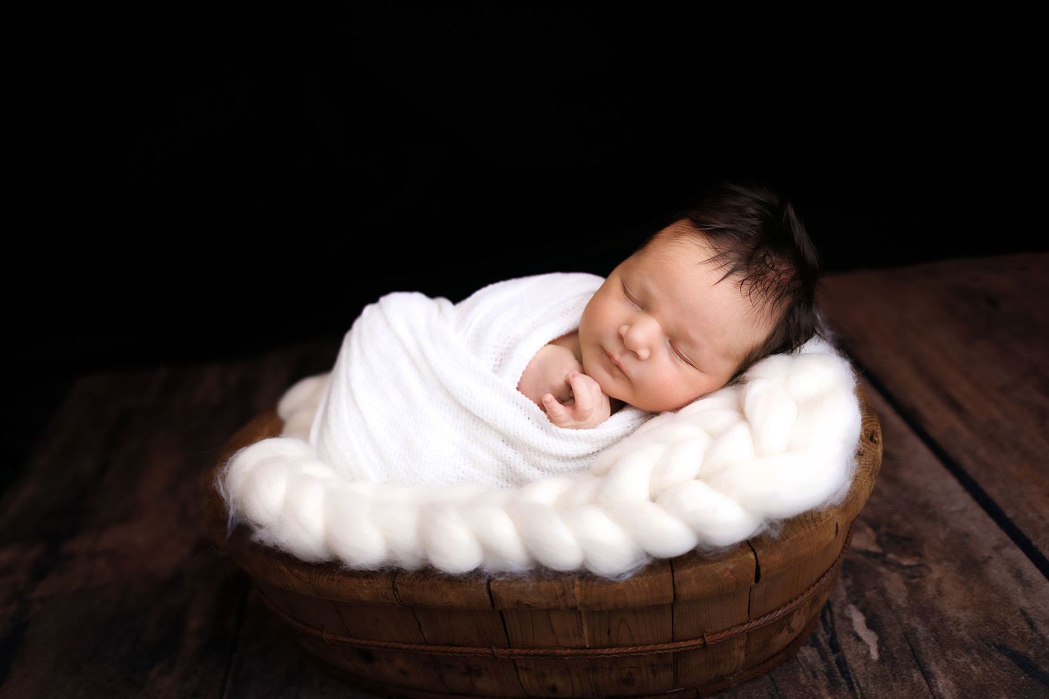 A collage of newborn baby photography with sleeping infants posed in rustic wooden bowls and soft white blankets.