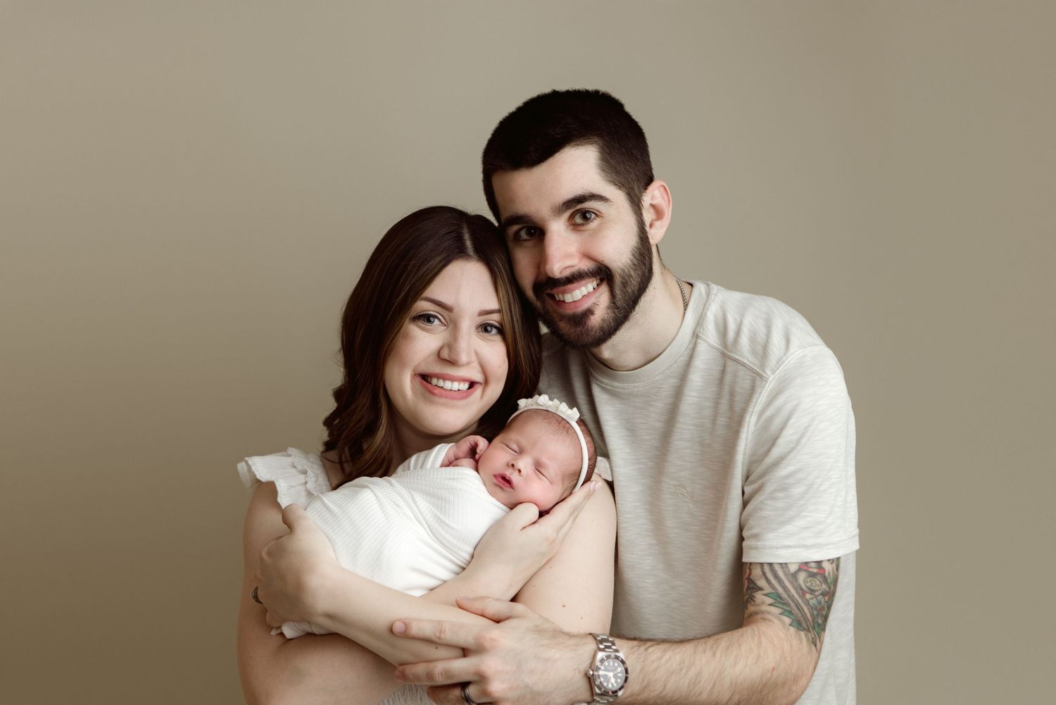 A series of tender family portraits showing parents with their newborn baby in neutral-toned studio photographs.