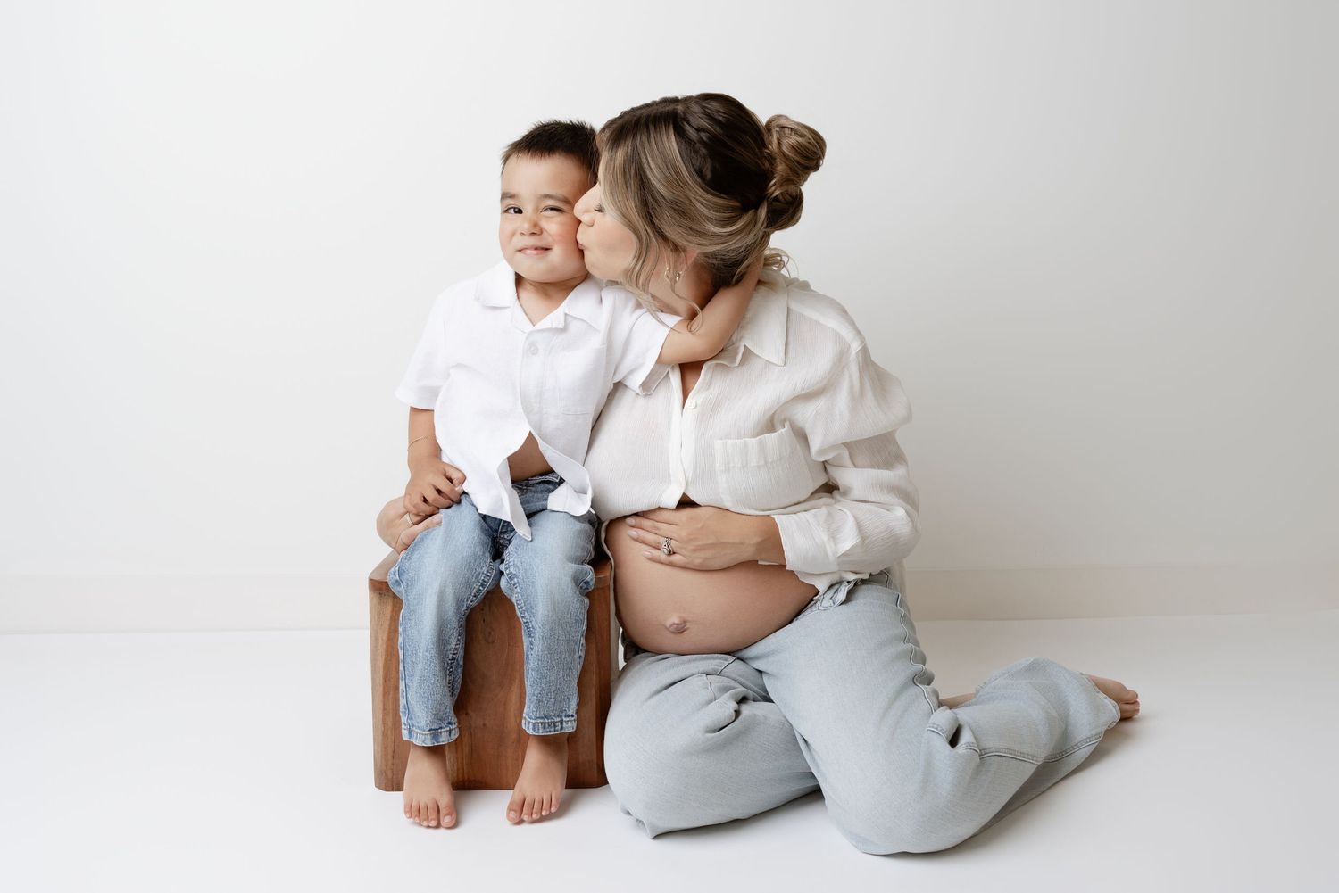 A series of minimalist studio photos showing parent and baby in soft neutral tones against a white background.