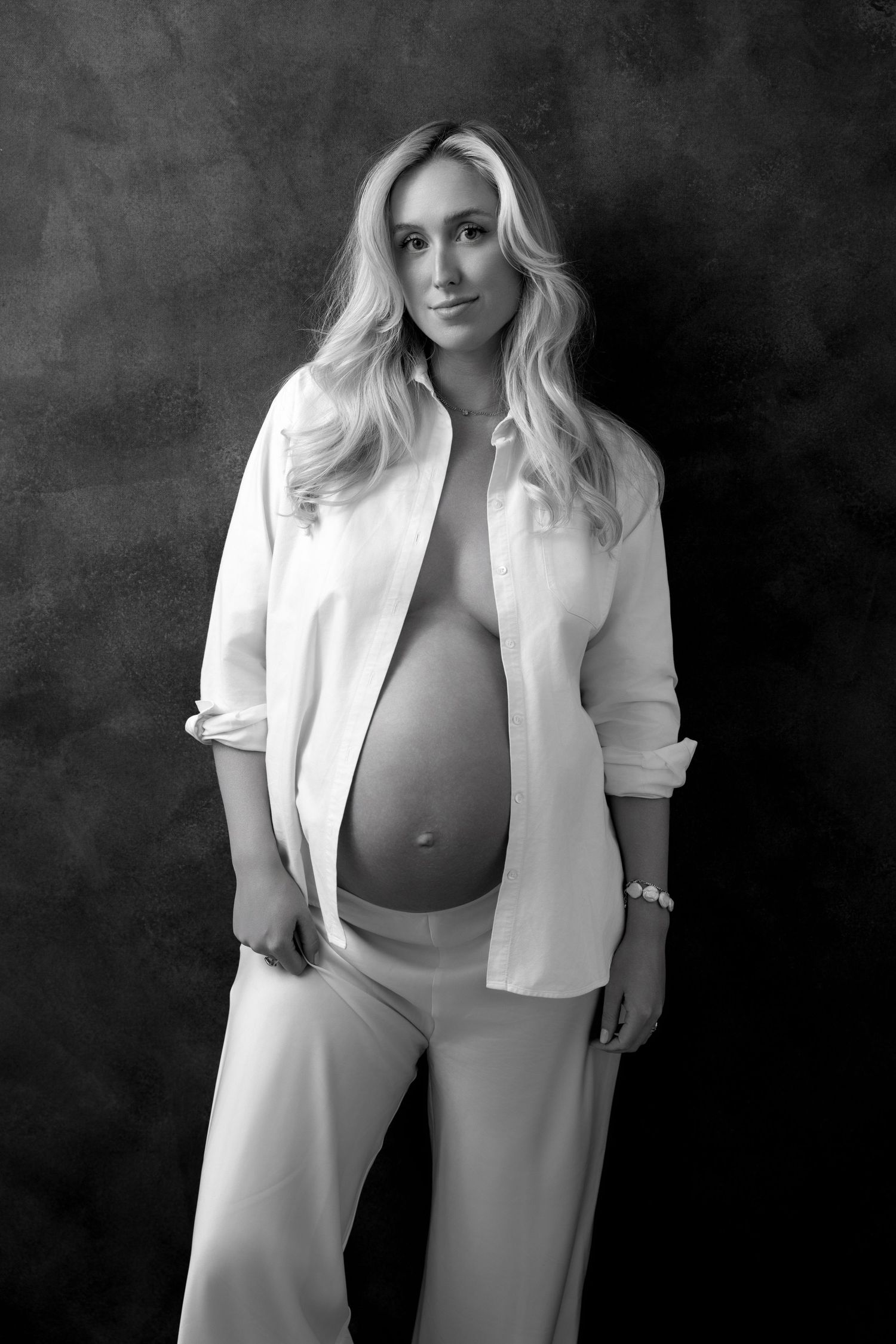Black and white artistic maternity photos with woman in white blazer.