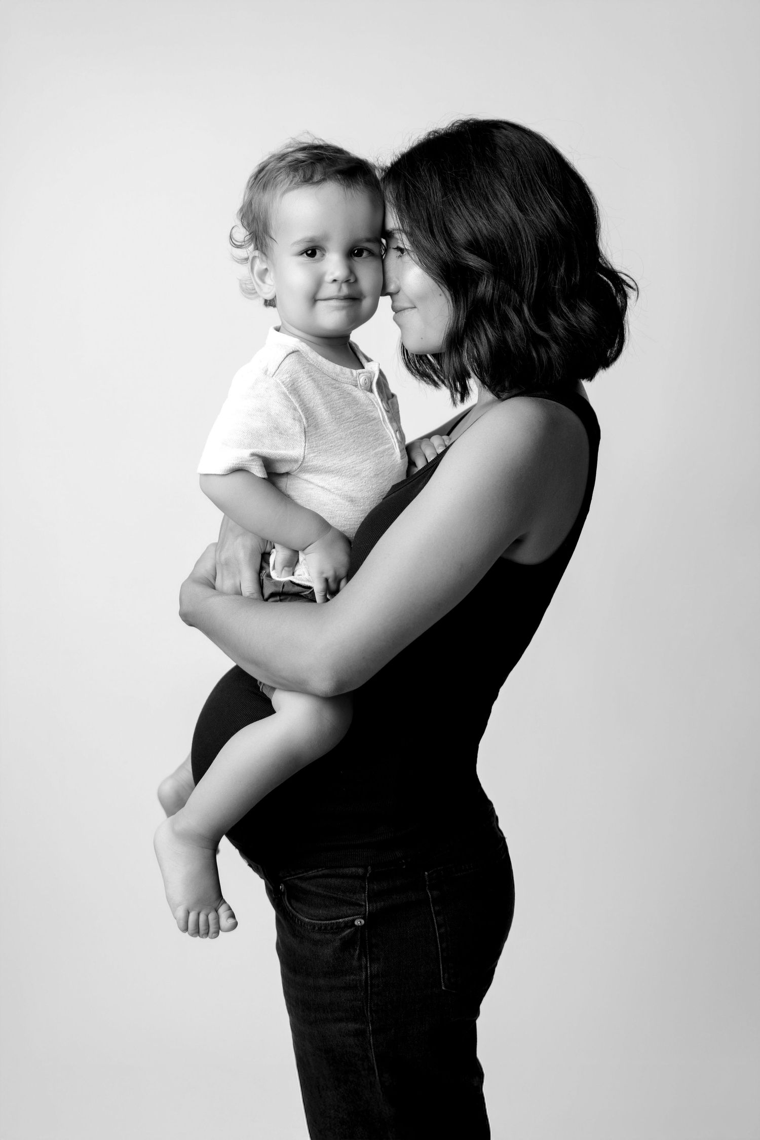 Black and white portraits showing tender moments between mother and baby.