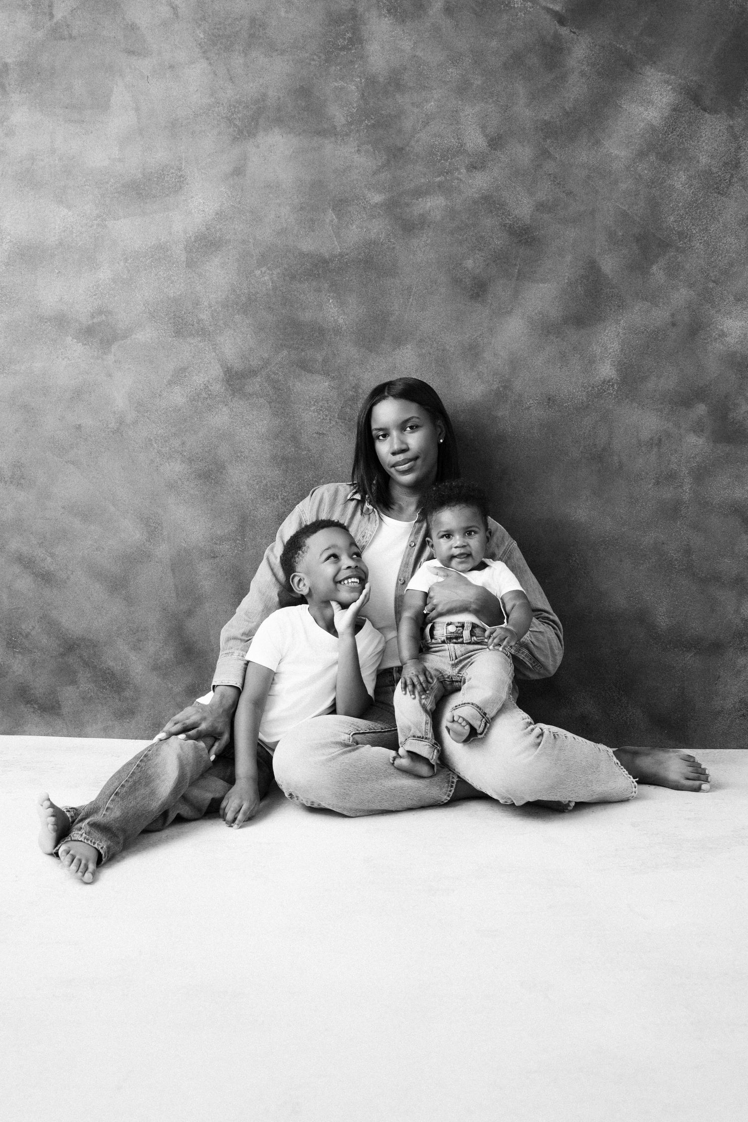 A series of black and white photographs showing a progressive sequence of playful poses on a studio floor.