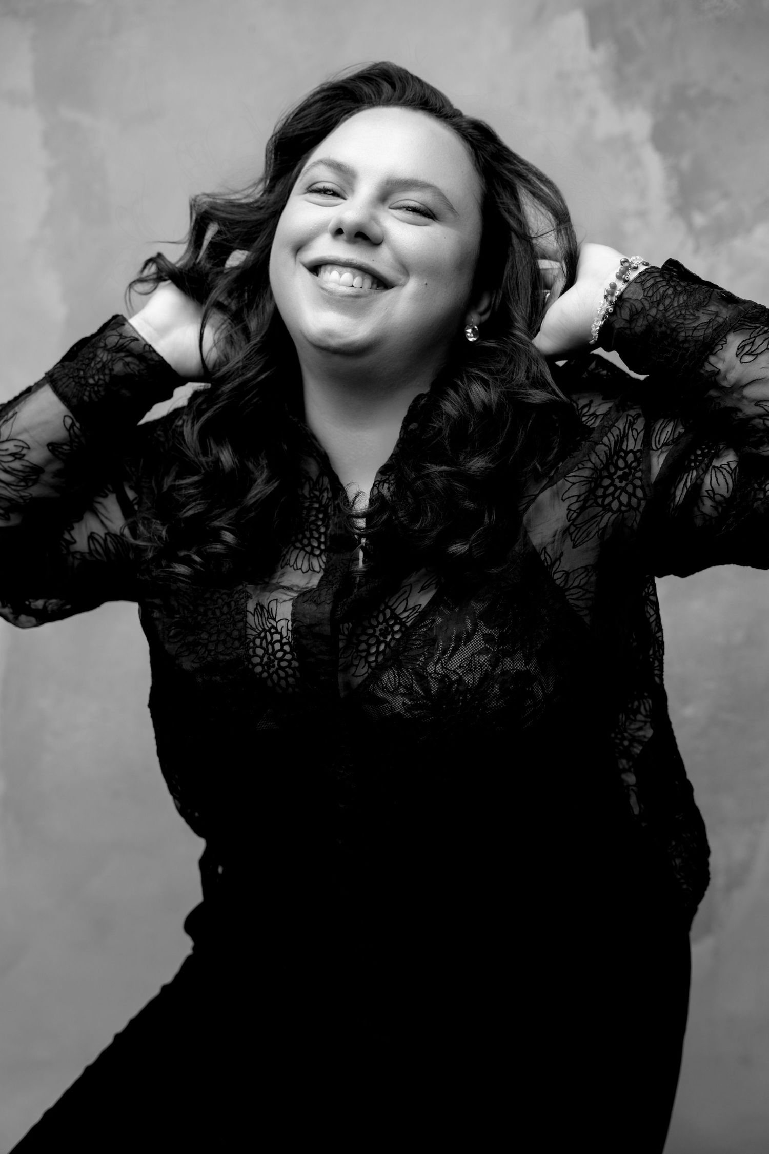 Expressive portrait series showing joyful movement in black lace against gray background.
