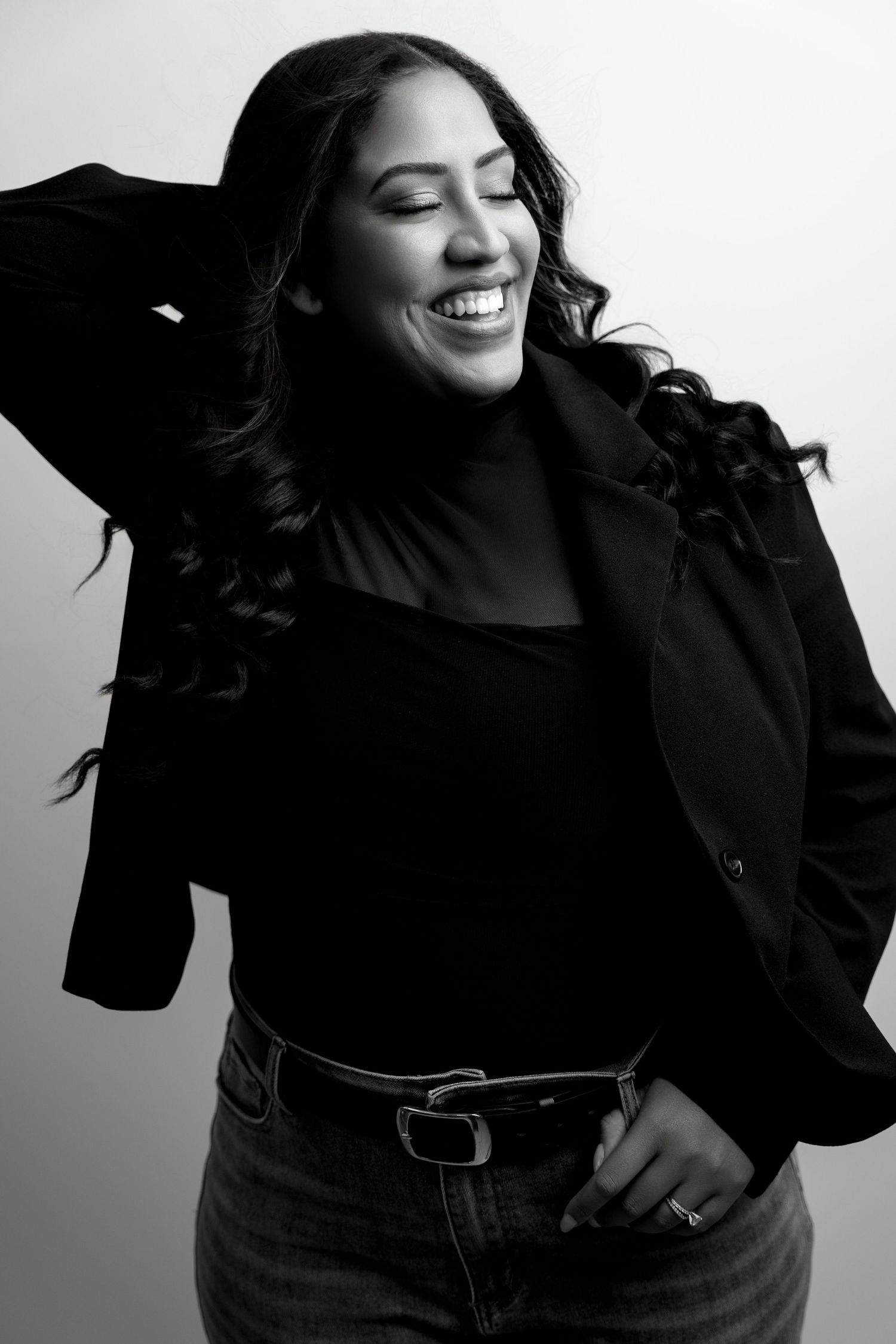 Black and white portrait series showing joyful expressions and casual poses against a studio backdrop.