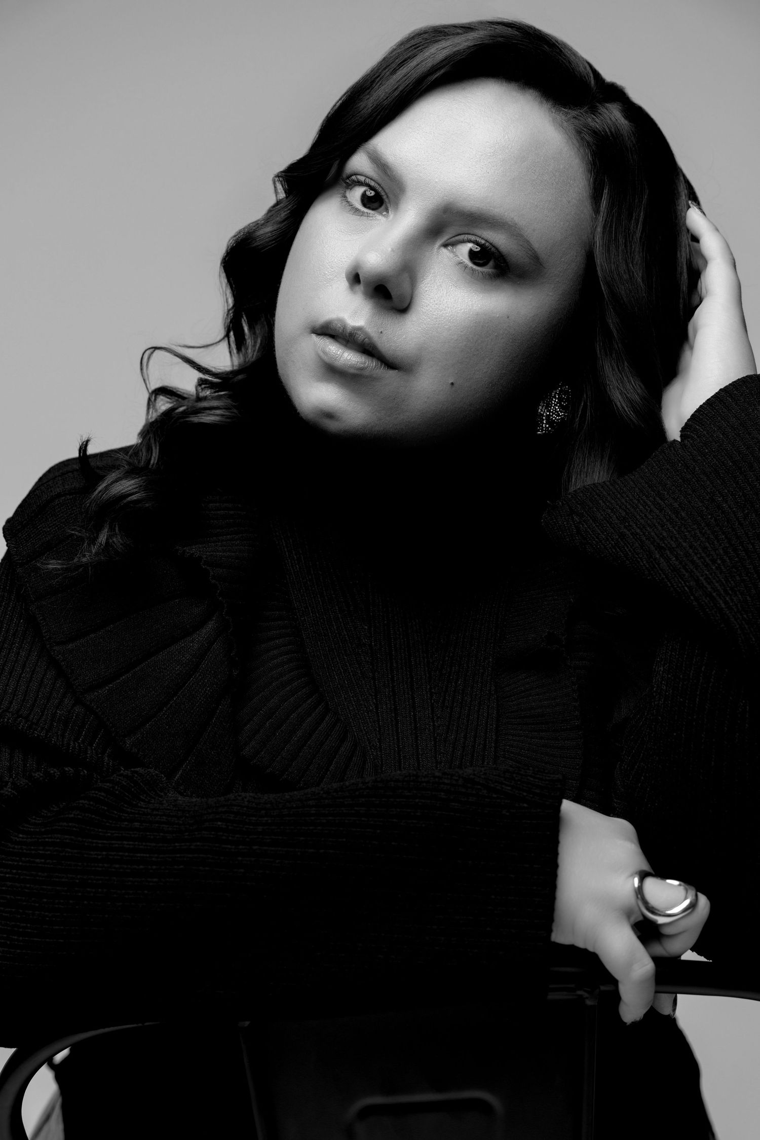 Moody black and white portraits showing artistic poses against grey studio background.