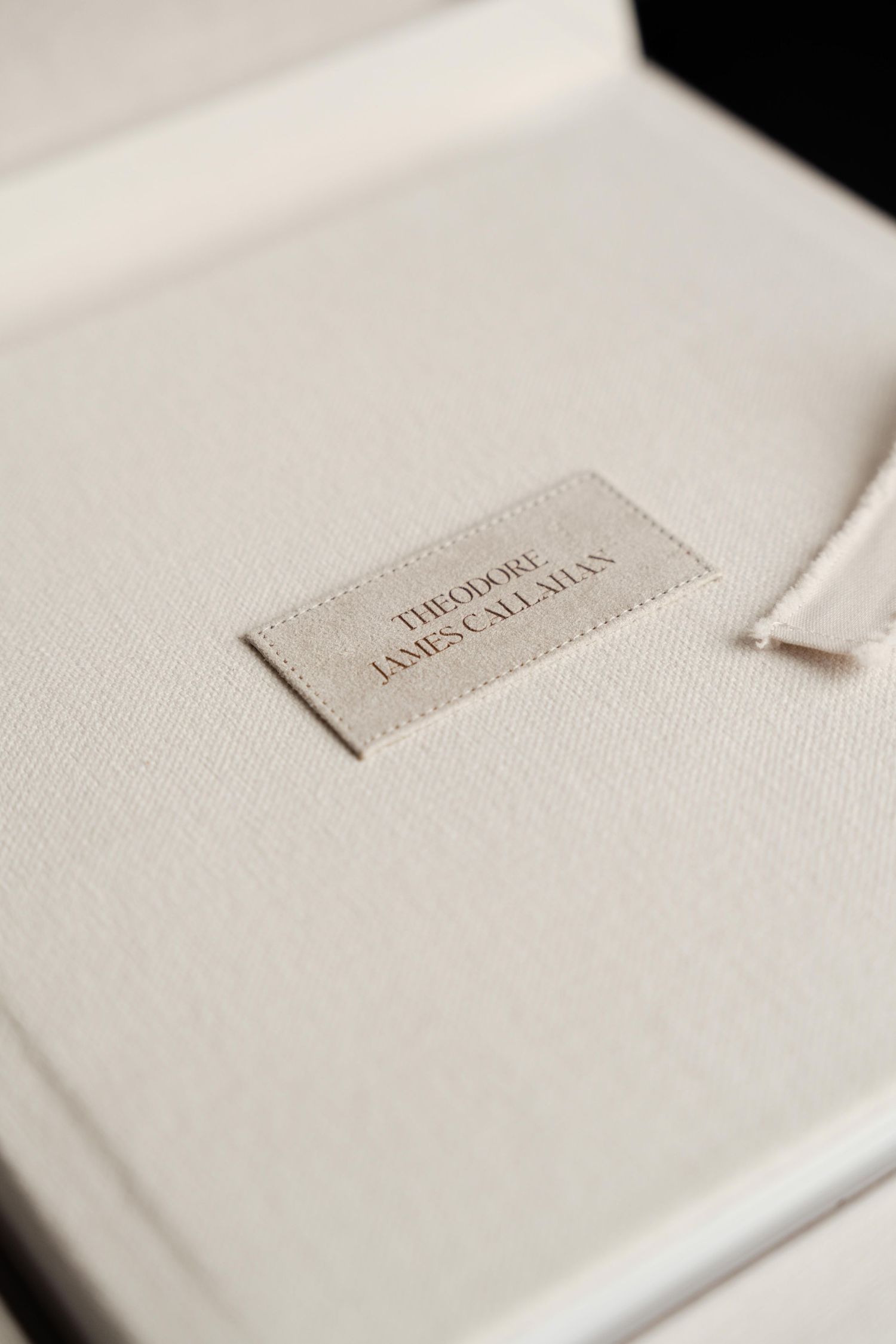 White hardcover book with elegant embossed text detail shown in a minimalist studio setting.