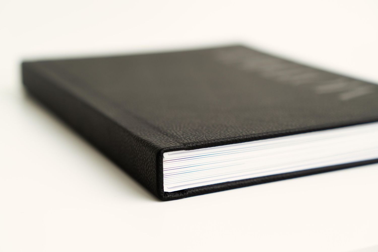 A black hardcover book shown in shallow depth of field against a white background.