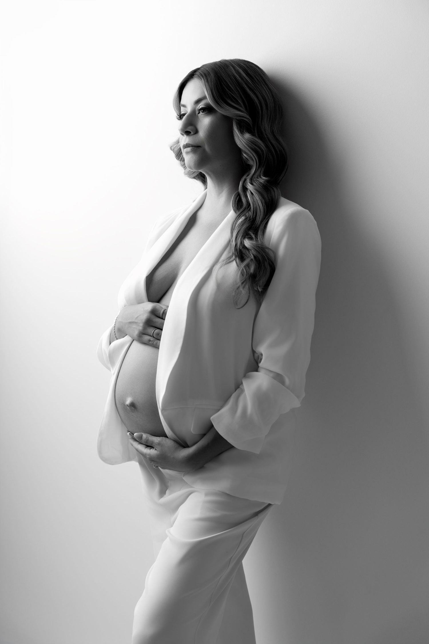 Black and white artistic fashion portrait series showing elegant poses in a white outfit against a minimalist background.