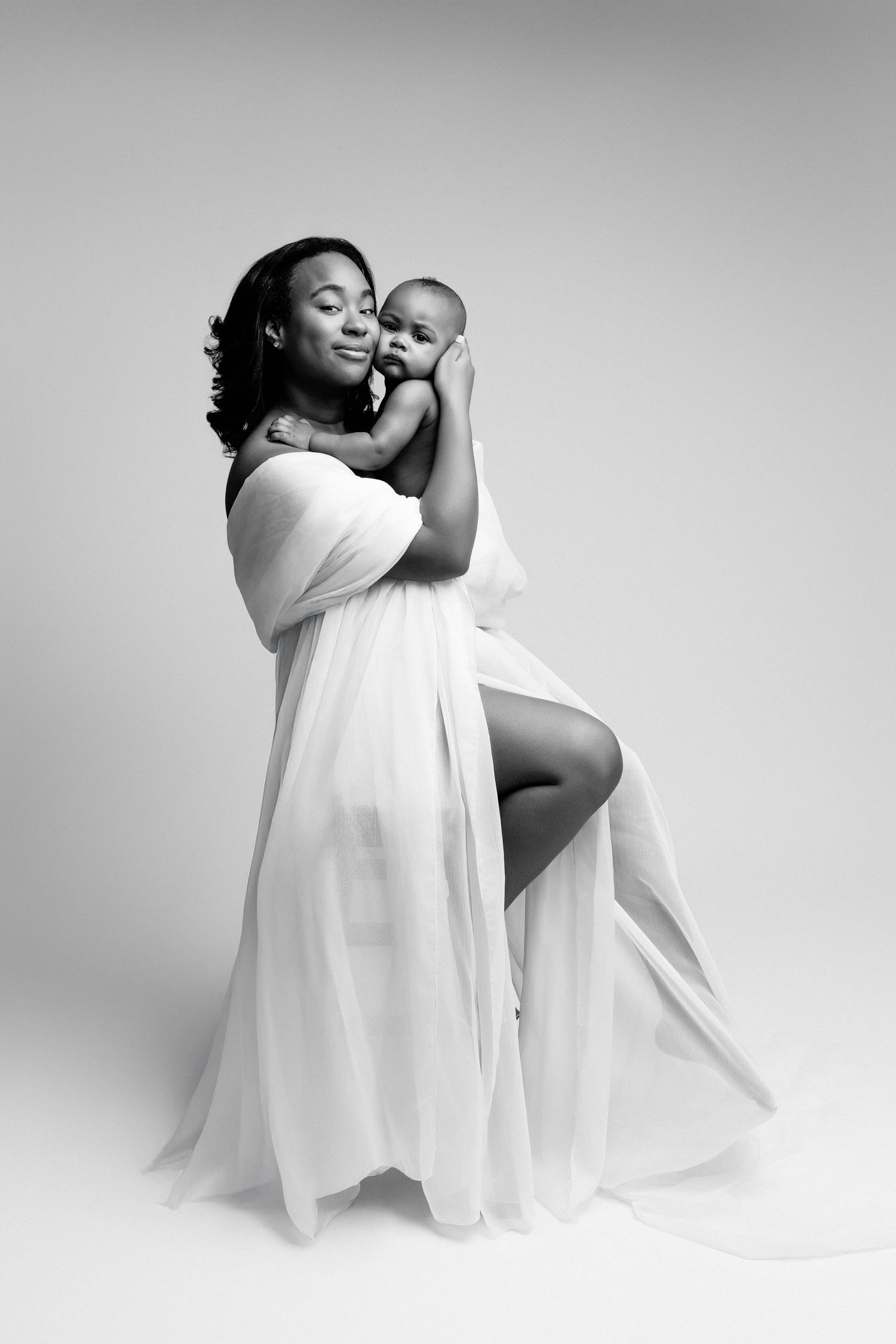 Artistic black and white photo series showing graceful poses in flowing white fabric against minimal studio backdrop.